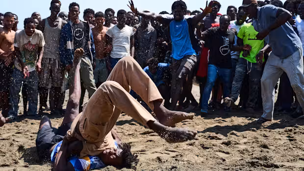 Die Migranten veranstalten Kämpfe am Strand.