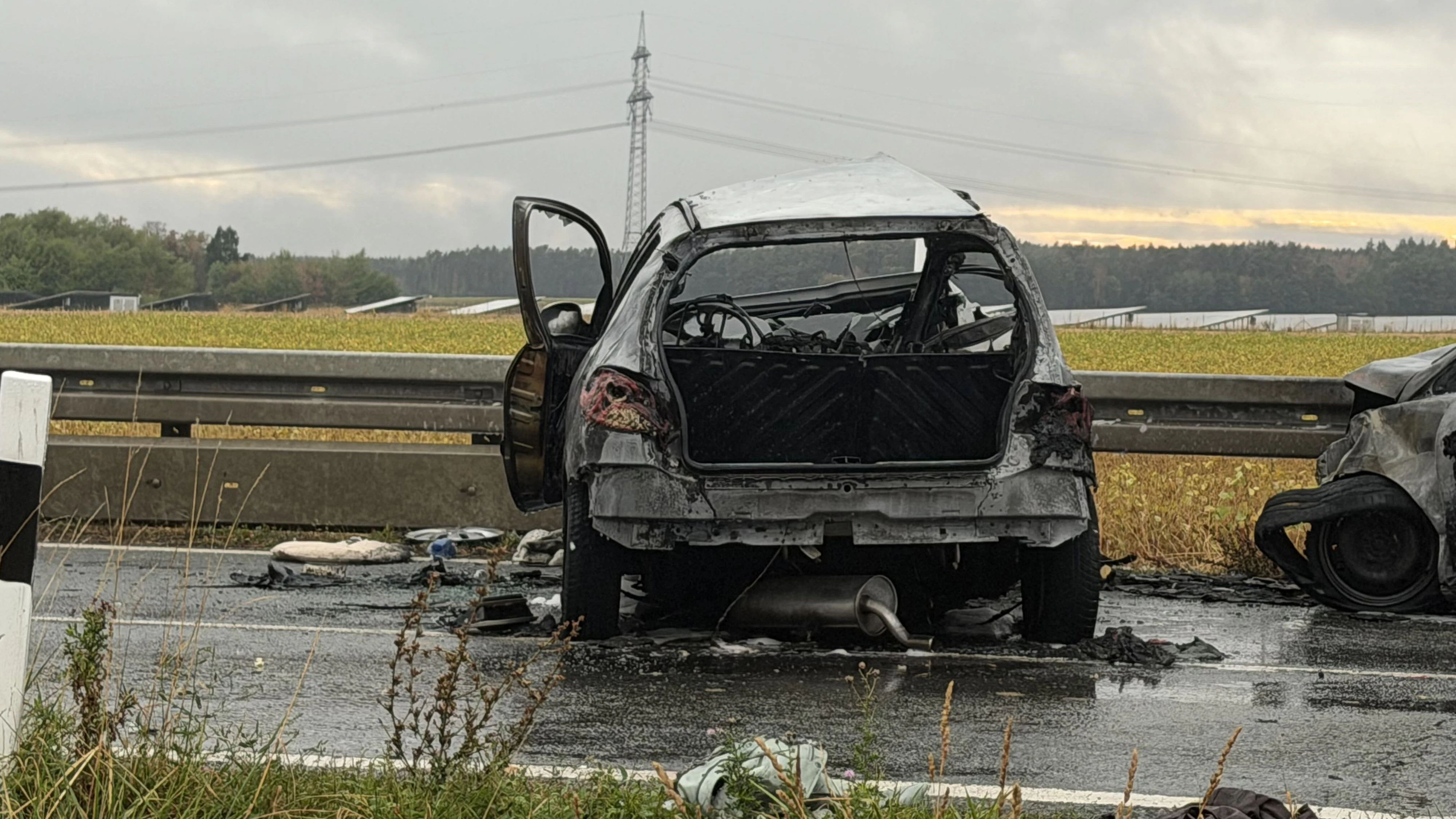 Bei einem schrecklichen Verkehrsunfall auf der Staatsstraße 2409 bei Steinbach nahe Cadolzburg in Mittelfrnaken sind am Freitagnachmittag (21.08.2026) eine Mutter und ihr Kind ums Leben gekommen. Eine weitere Person wurde schwerstverletzt in ein Krankenhaus gebracht. Eines der beteiligten Fahrzeuge geriet nach der Kollision direkt in Brand. Nach den Informationen der Polizei und unserem Reporter war ein Peugeot von Ammerndorf in Richtung Cadolzburg unterwegs. Im Bereich einer Rechtskurve bei Schlehen kam es aus bislang ungeklärter Ursache zum Zusammenstoß mit einem entgegenkommenden Ford. Durch die Wucht des Aufpralls der Peugot in Brand. Ersthelfer reagierten sofort und versuchten noch, die Insassen aus dem Fahrzeug zu retten. Die Mutter, die am Steuer saß, konnte von ihnen aus dem Wagen gezogen werden. Noch an der Unfallstelle begannen die Helfer mit Reanimationsmaßnahmen. Trotz aller Bemühungen kam für die Frau jedoch jede Hilfe zu spät. Sie starb an der Unfallstelle. Für ihr Kind, das auf dem Beifahrersitz saß, gab es keine Rettung mehr. Es befand sich noch im Fahrzeug, als dieses in Flammen stand, und kam bei dem Unfall ums Leben. Der Fahrer des zweiten beteiligten Autos erlitt schwerste Verletzungen. 