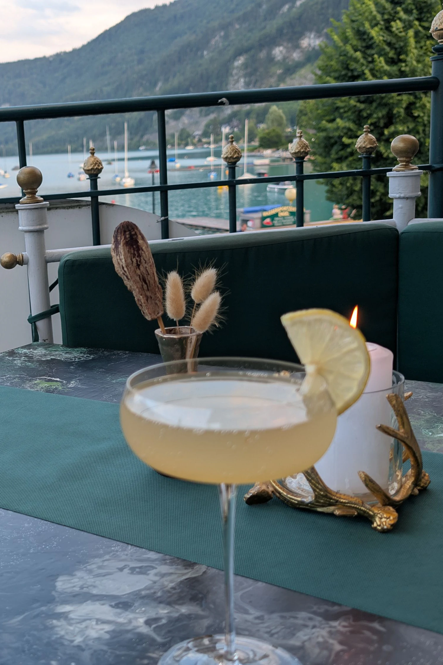 Unten glitzert der Wolfgangsee in der Abendsonne, oben im "Atelier Fischer" der Aperitif in Form eines Le Tribute Gin mit Palo Santo und Yuzu
