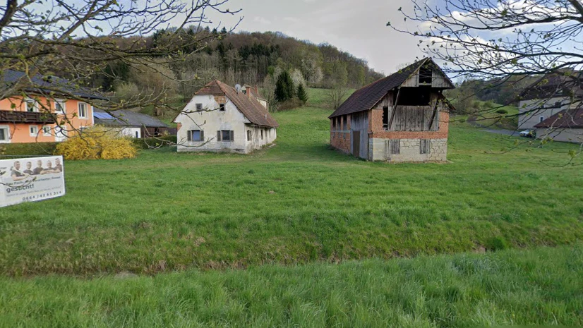 Blick von der L219 Kölldorferstraße auf das Areal: Zwischen den beiden Gebäuden sind die scheinbar störenden Übungswracks der Feuerwehr (nicht im Bild) aufgeschlichtet.