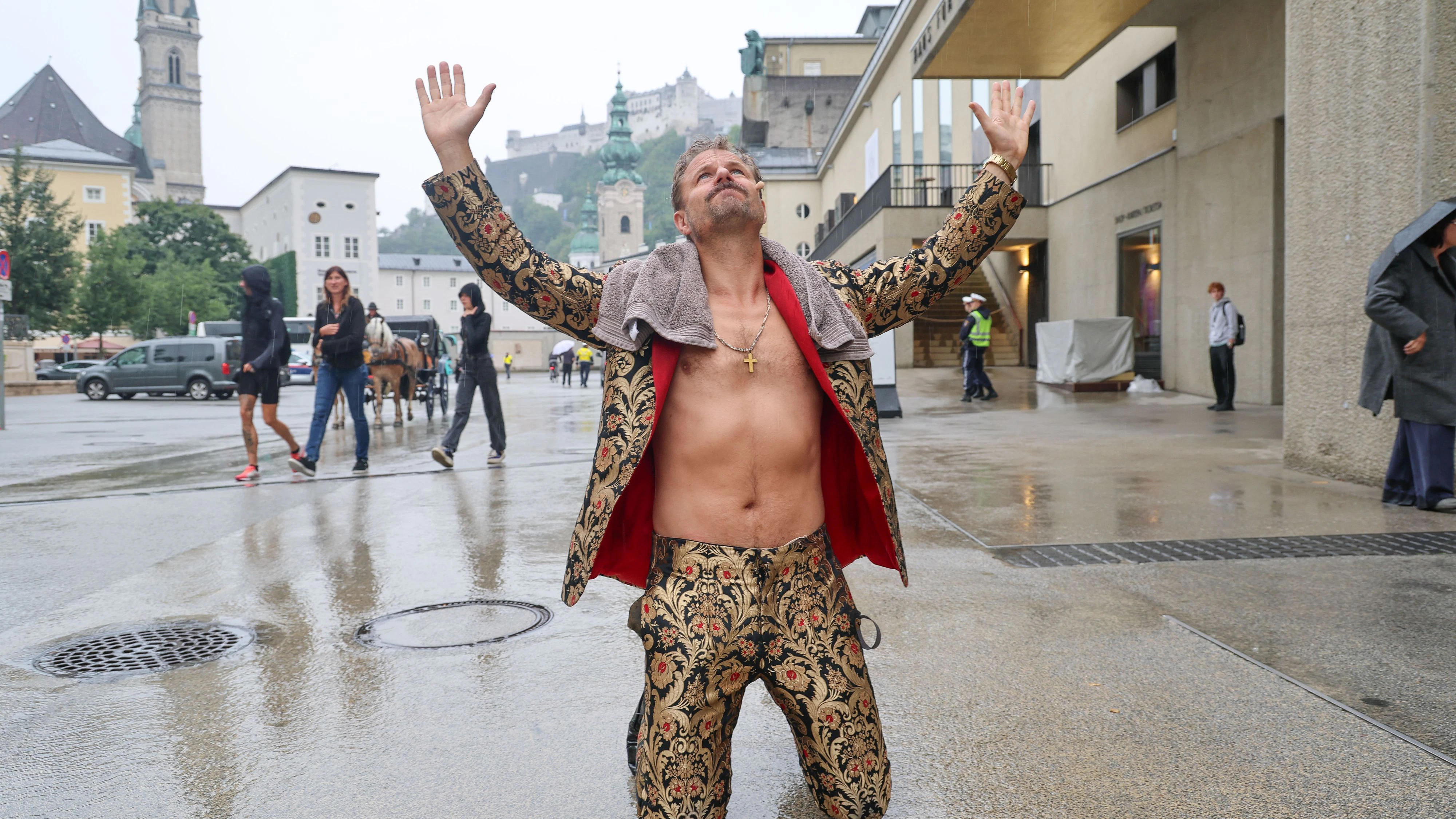Philipp Hochmair im Jedermann Outfit (Goldener Anzug) im Regen vor dem Festspielhaus