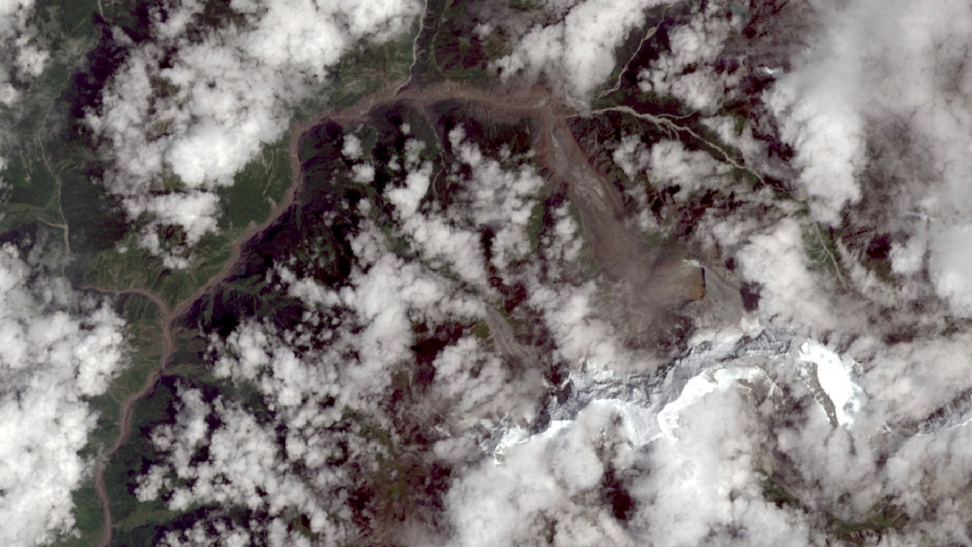 Eine Satellitenaufnahme zeigt einen eingestürzten Gletscher am Langtang Lirung (rechts unten) nach der verheerenden Schlammlawine. Die Eis- und Geröllmassen dürften laut Experten den darunterliegenden Fluss Lhende verlegt und aufgestaut haben. Als dieser Damm brach, dürfte die gigantische Sturzflut durch das Tal (oben) gerauscht sein..