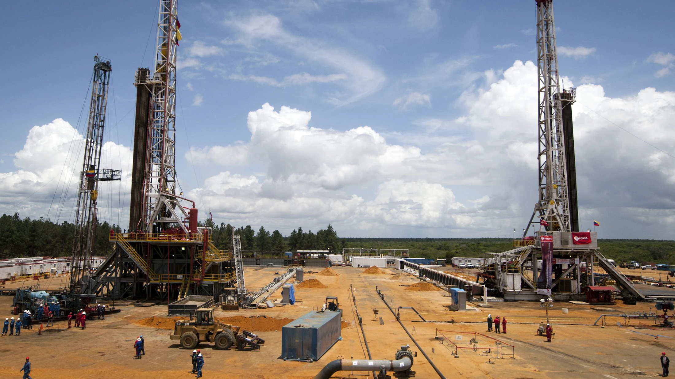 Oil workers work at a petroleum area operated by Venezuelan state oil company PDVSA in Morichal July 28, 2011. Venezuela's state oil company PDVSA will invest $18 billion this year with $2 billion of that earmarked for new output from the OPEC nation's vast Orinoco heavy crude fields, officials said on Thursday. Venezuela's oil reserves are now considered to be the world's largest but output has slipped under President Hugo Chavez. PDVSA aims to pump 146,000 barrels per day more from the Orinoco region by the end of 2011. REUTERS/Carlos Garcia Rawlins (VENEZUELA - Tags: POLITICS ENERGY BUSINESS)