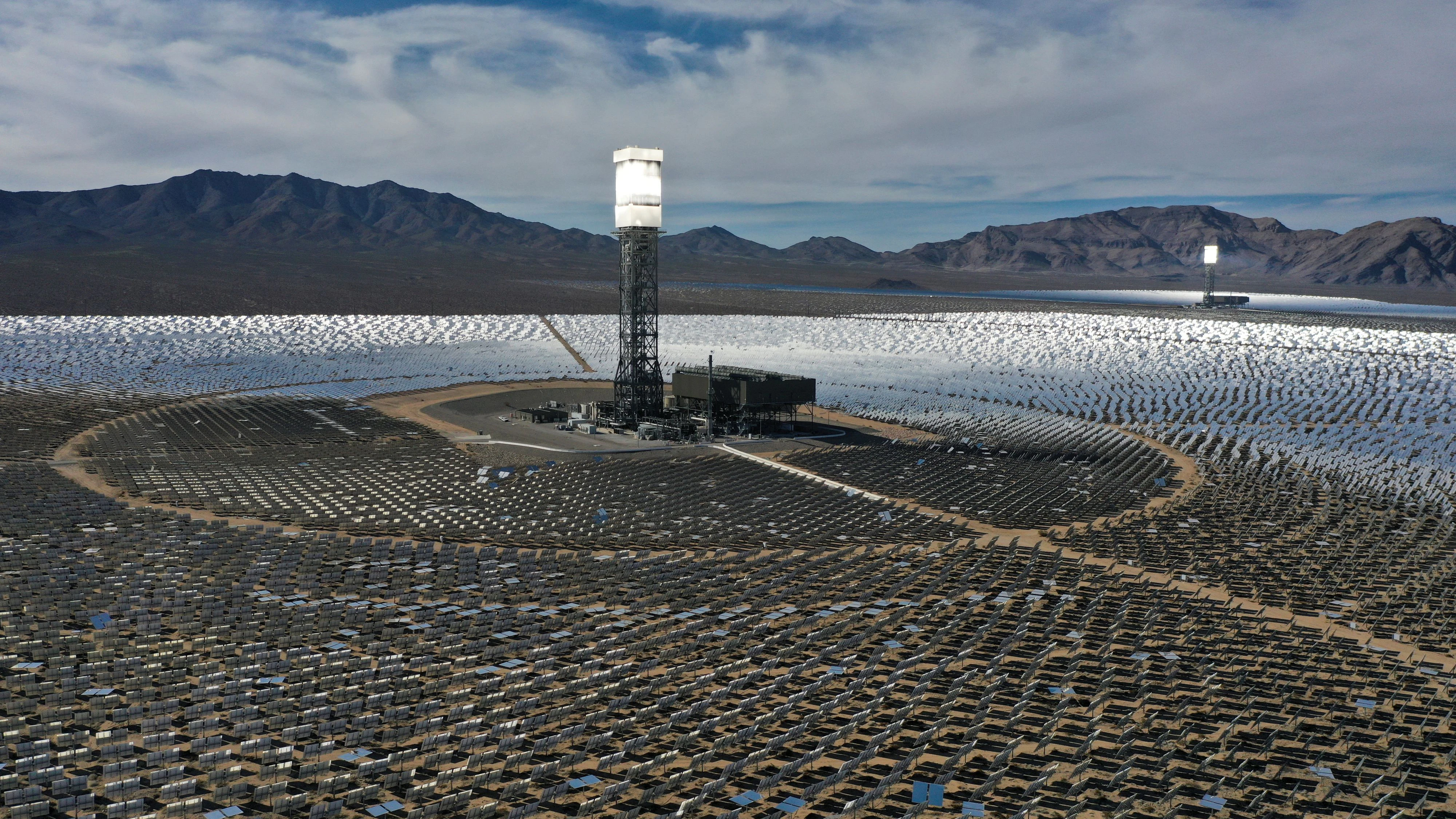 Felder aus Heliostat-Spiegeln reflektieren Sonnenlicht auf einen an Solartürmen montierten Dampferzeuger im Ivanpah Solar Electric Generating System - dem weltweit größten solarthermischen Kraftwerk - in der Mojave-Wüste bei Nipton, Kalifornien (USA)