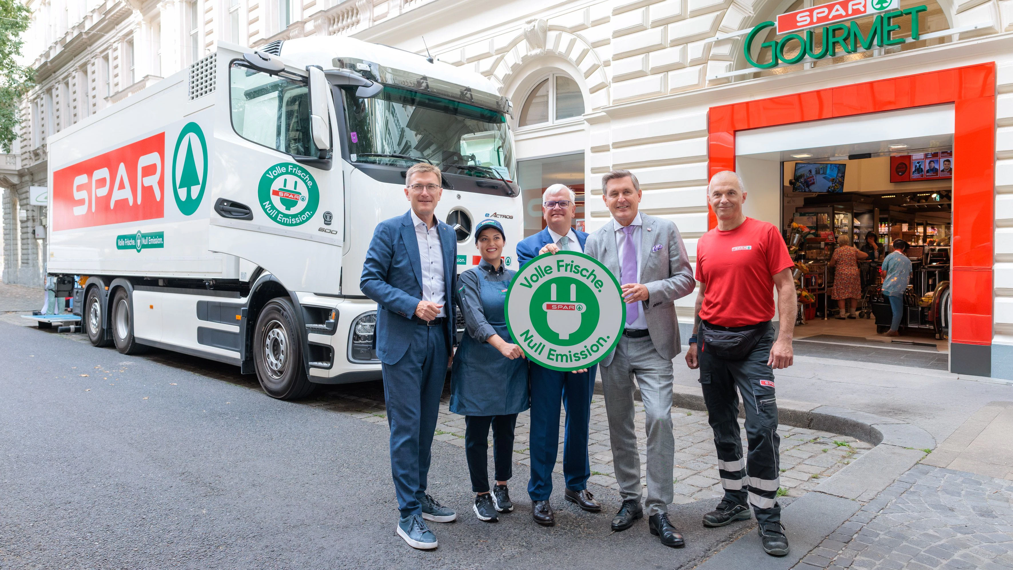 Dicker Öko-Lkw im Einsatz (v.l.): Spar-Geschäftsführer Alois Huber mit Spar-Mitarbeiterin Ivana Pejkic, Spar-Vorstand Marcus Wild, Minister Peter Hanke und Spar-Lkw-Fahrer Markus Hofegger.