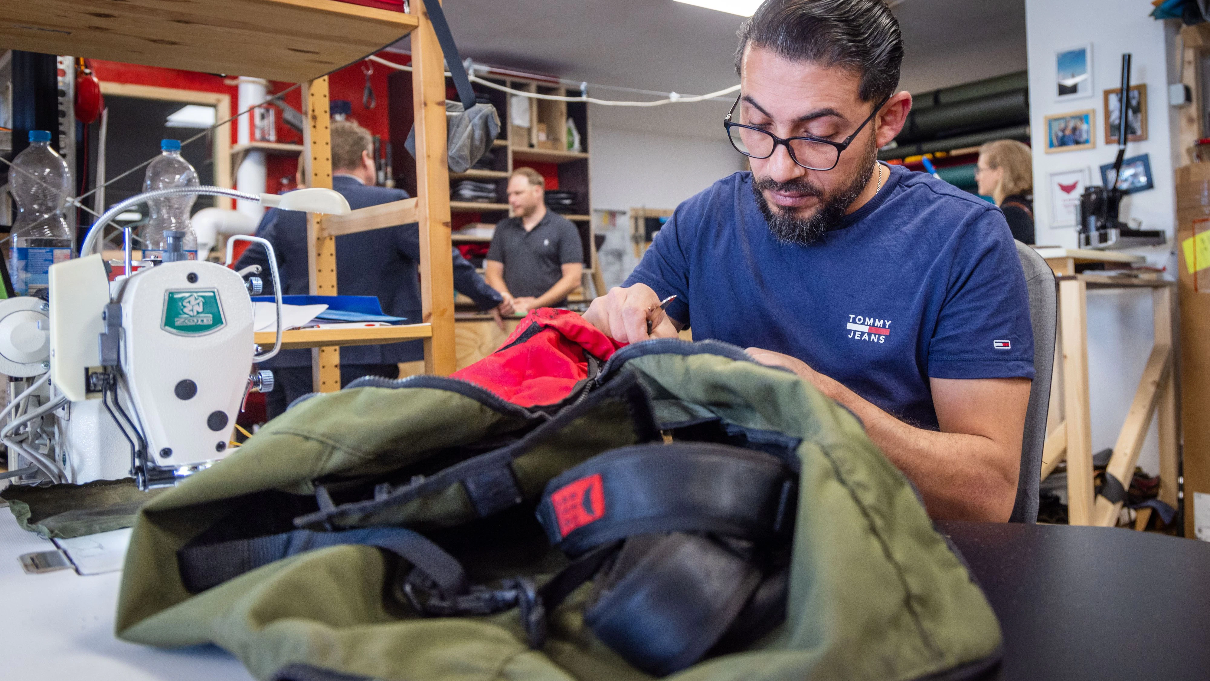 Abdulhadi Shehibar aus Syrien näht in der Taschenmanufaktur "Red Rebane" in Schwerin, Mecklenburg-Vorpommern, einen Rucksack. Das Unternehmen beschäftigt Menschen mit schwerer Behinderung und Flüchtlinge. Archivbild, 2022