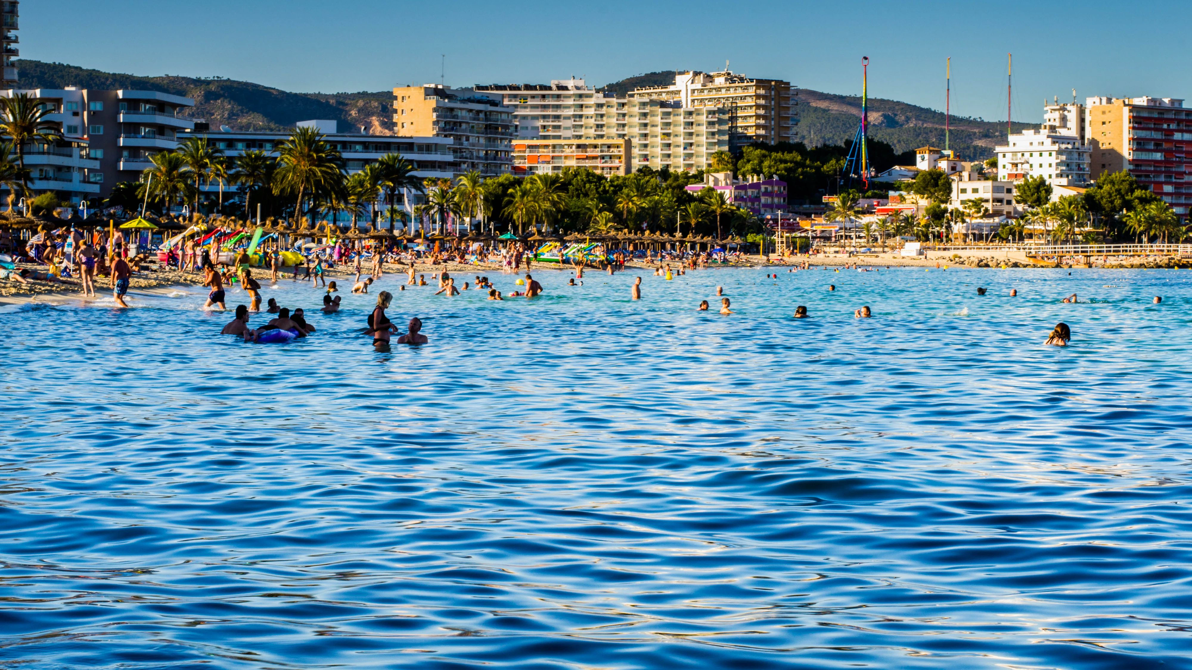 Mallorca (Magaluf), Spain - July 31, 2013: Picture taken at Magaluf beach near Palma y Mallorca Spain during a summer evening. Many people swimming and sunbathing can be observed as well as hotels in the background.