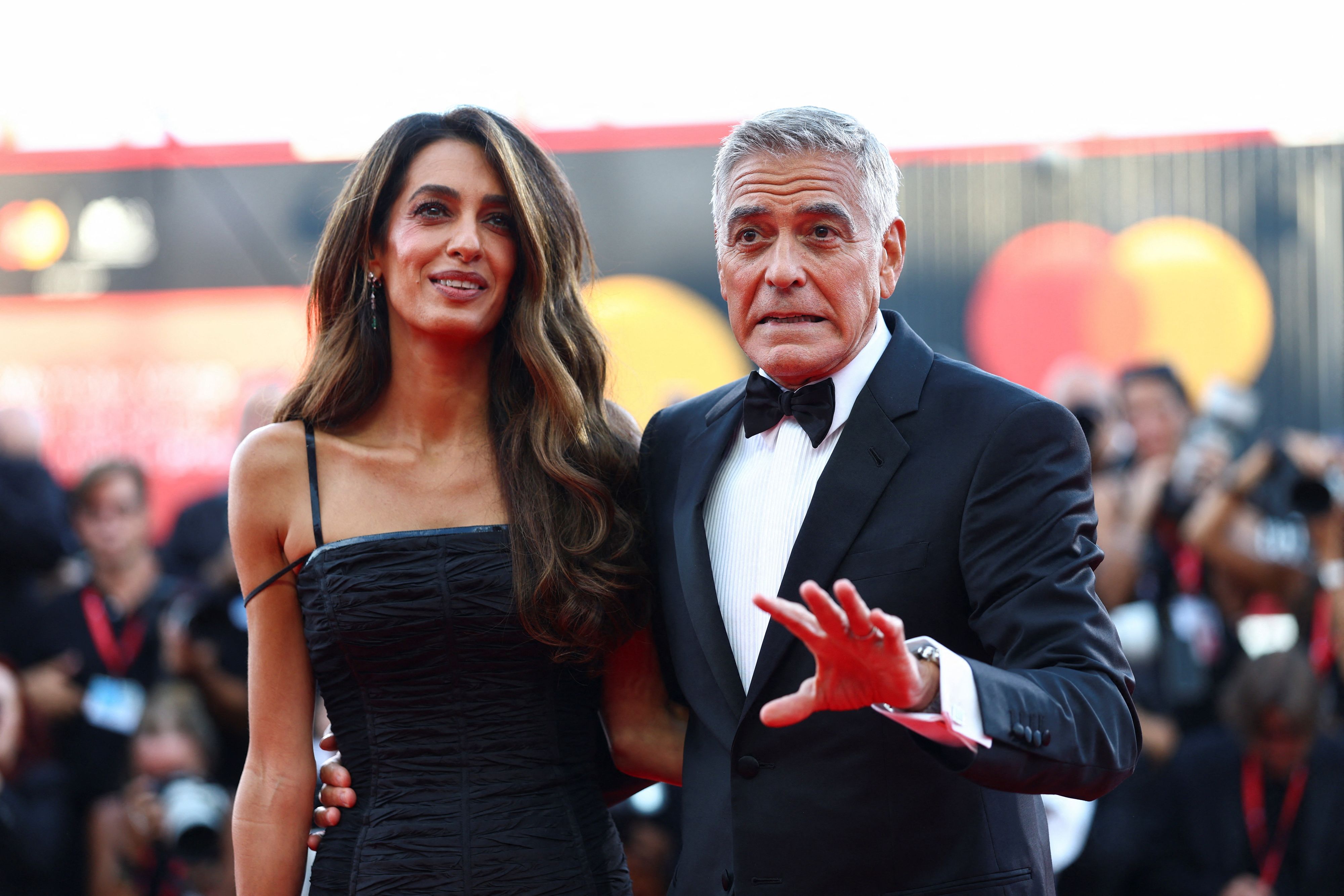George Clooney albert bei der Verleihung des Goldenen Löwen in Venedig mit den Fotografen herum.