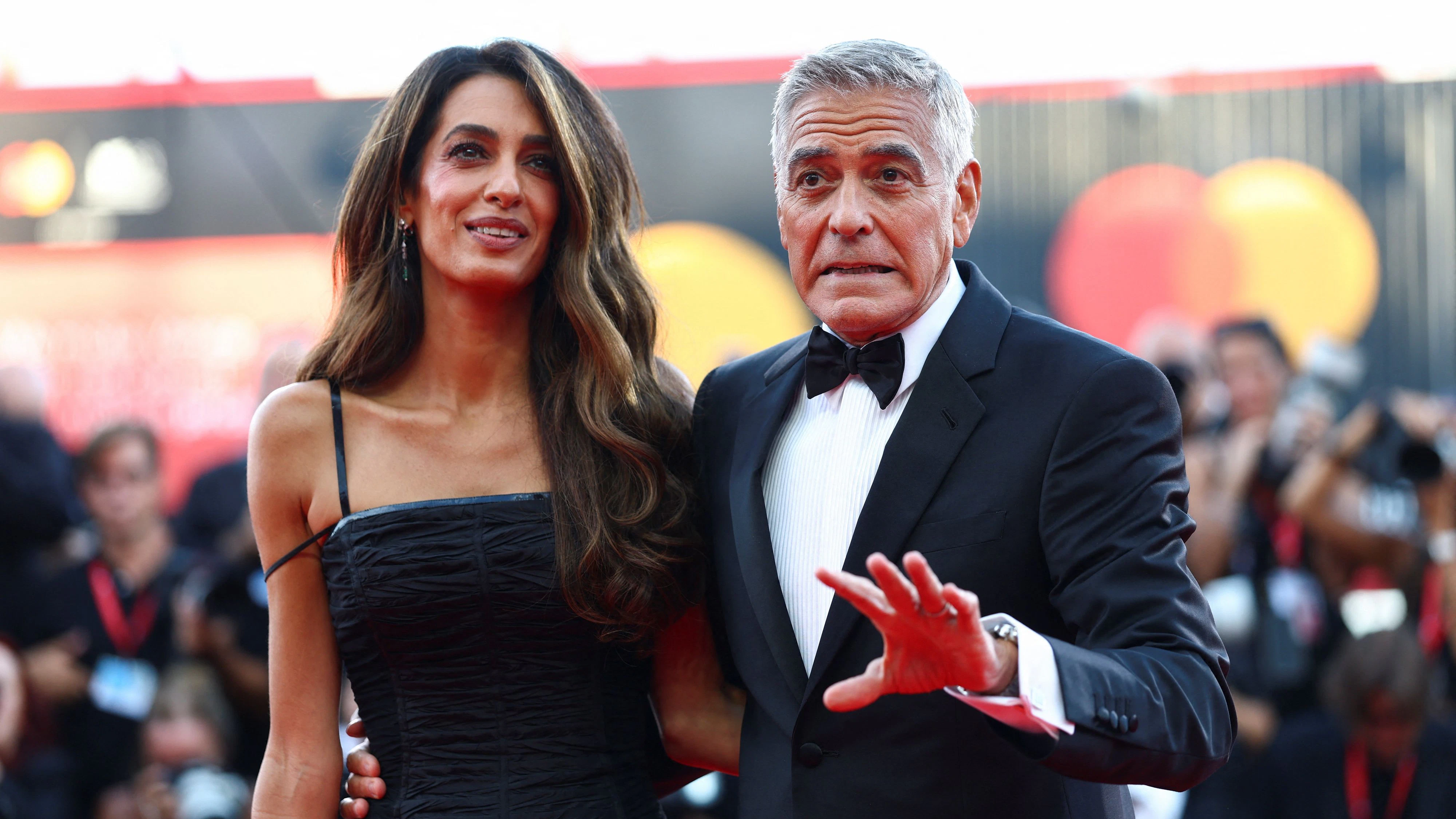 George Clooney albert bei der Verleihung des Goldenen Löwen in Venedig mit den Fotografen herum.