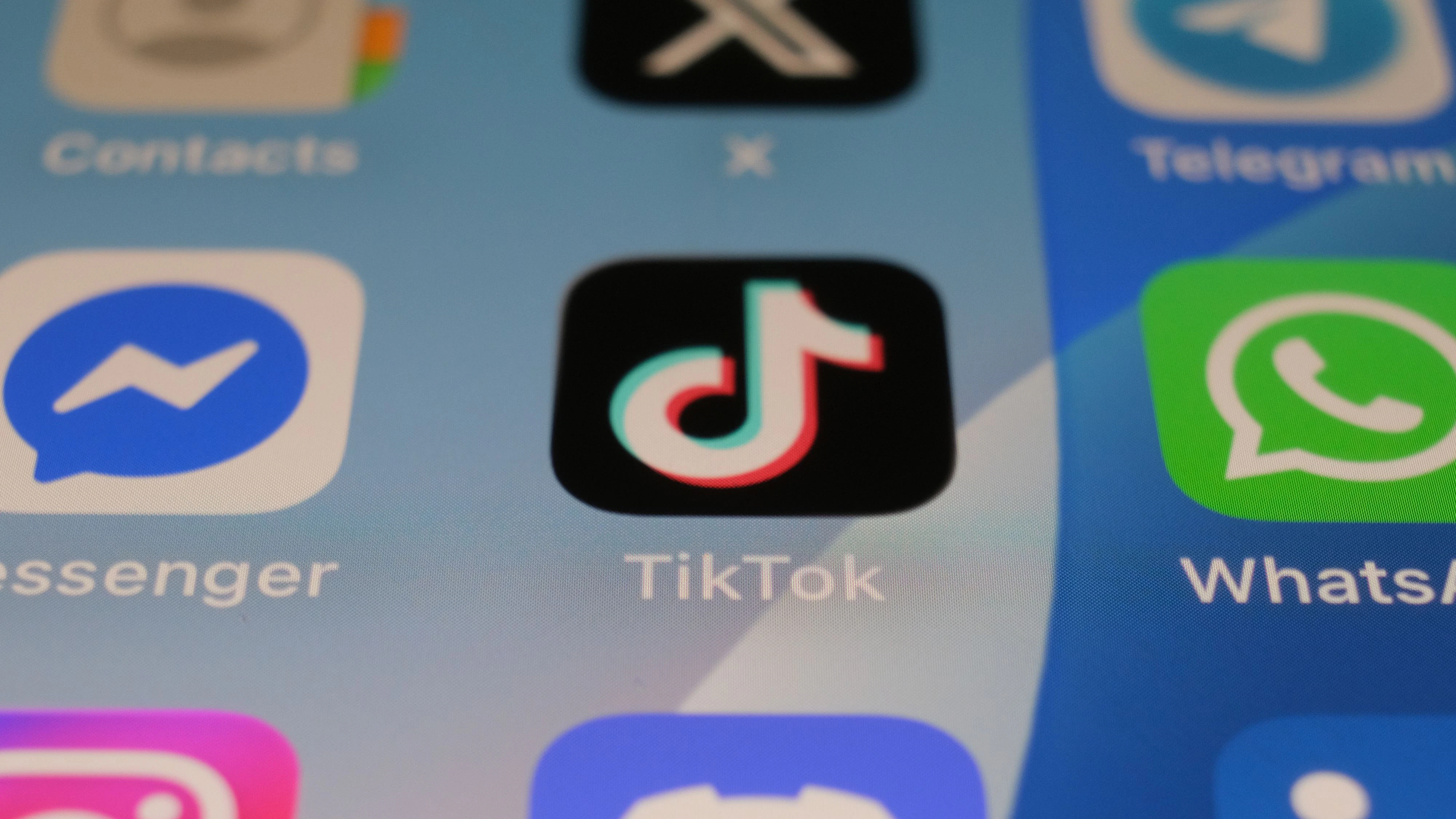 Leiden, Netherlands - July 10, 2026: Close-up of a TikTok app icon displayed on a smartphone home screen among other social media apps including Messenger and WhatsApp.