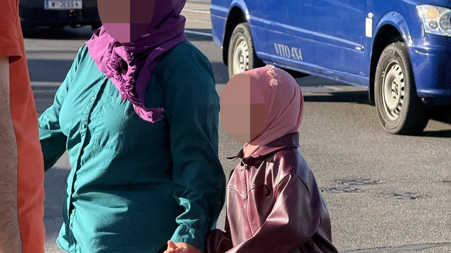 Ein Mädchen mit Kopftuch wird von ihrer Mutter in die islamische Privatschule gebracht.