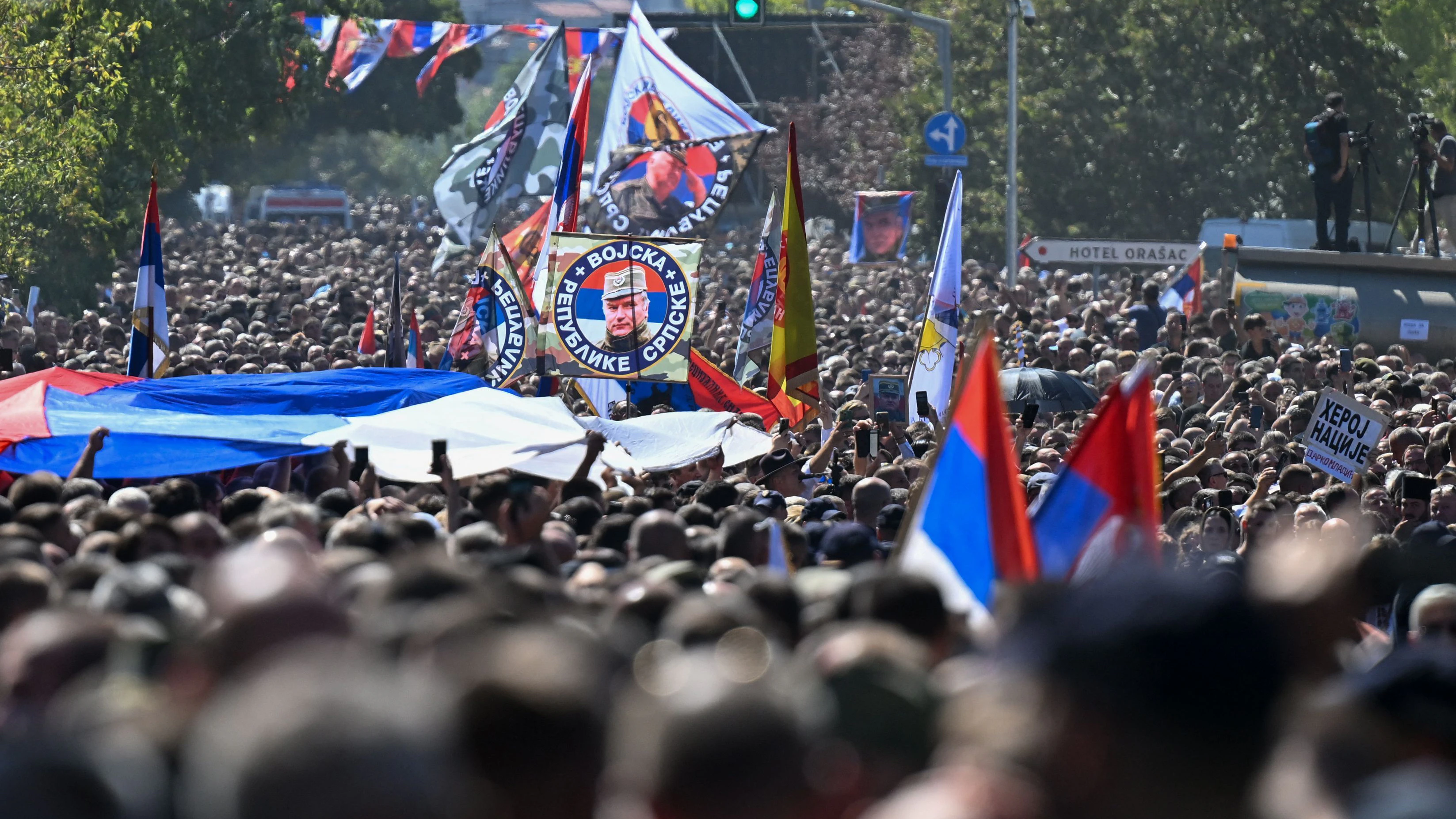 Mourners hold Serbian flags and portraits of late Bosnian Serb military leader Ratko Mladic during a procession to cemetery on the day of the funeral ceremony for Ratko Mladic in Belgrade, on September 7, 2026. Mladic, 84, died last week after suffering several strokes while serving a life sentence in The Hague for war crimes committed during the 1990s war in Bosnia. (Photo by OLIVER BUNIC / AFP)