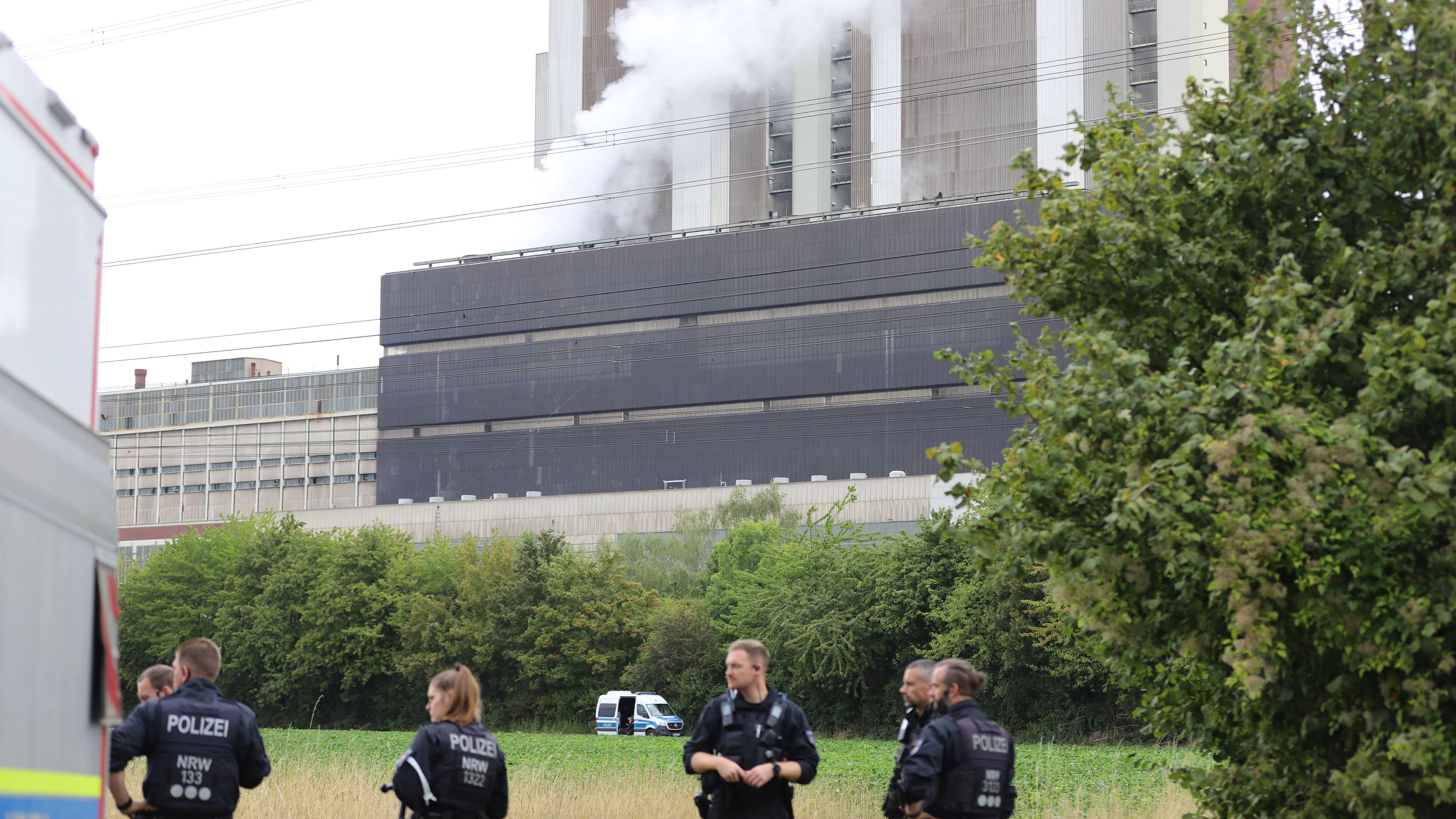08 September 2026, North Rhine-Westphalia, Eschweiler: Police officers are standing near the Weisweiler power plant. Since Monday afternoon, a large number of police officers have been deployed around the power plant and have been conducting an intensive search for the suspect, who is believed to have carried out several acts of sabotage against the German power grid. Photo: Sascha Thelen/dpa