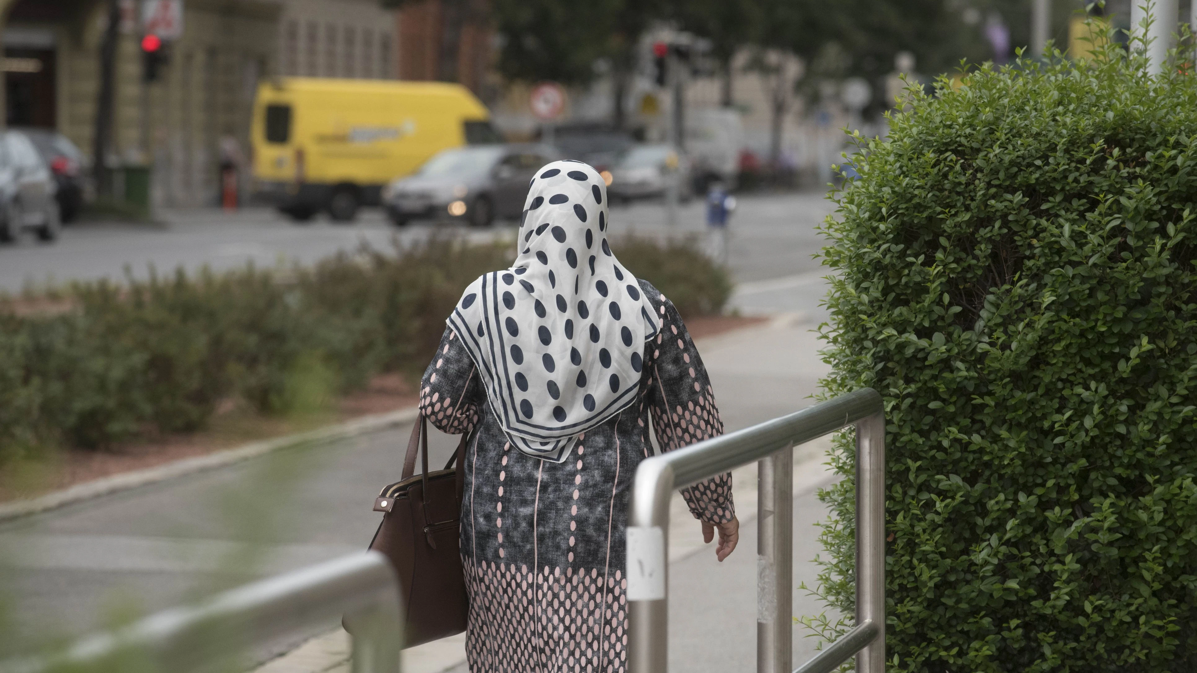 a muslim woman wearing a headscarf, religious dress and symbol