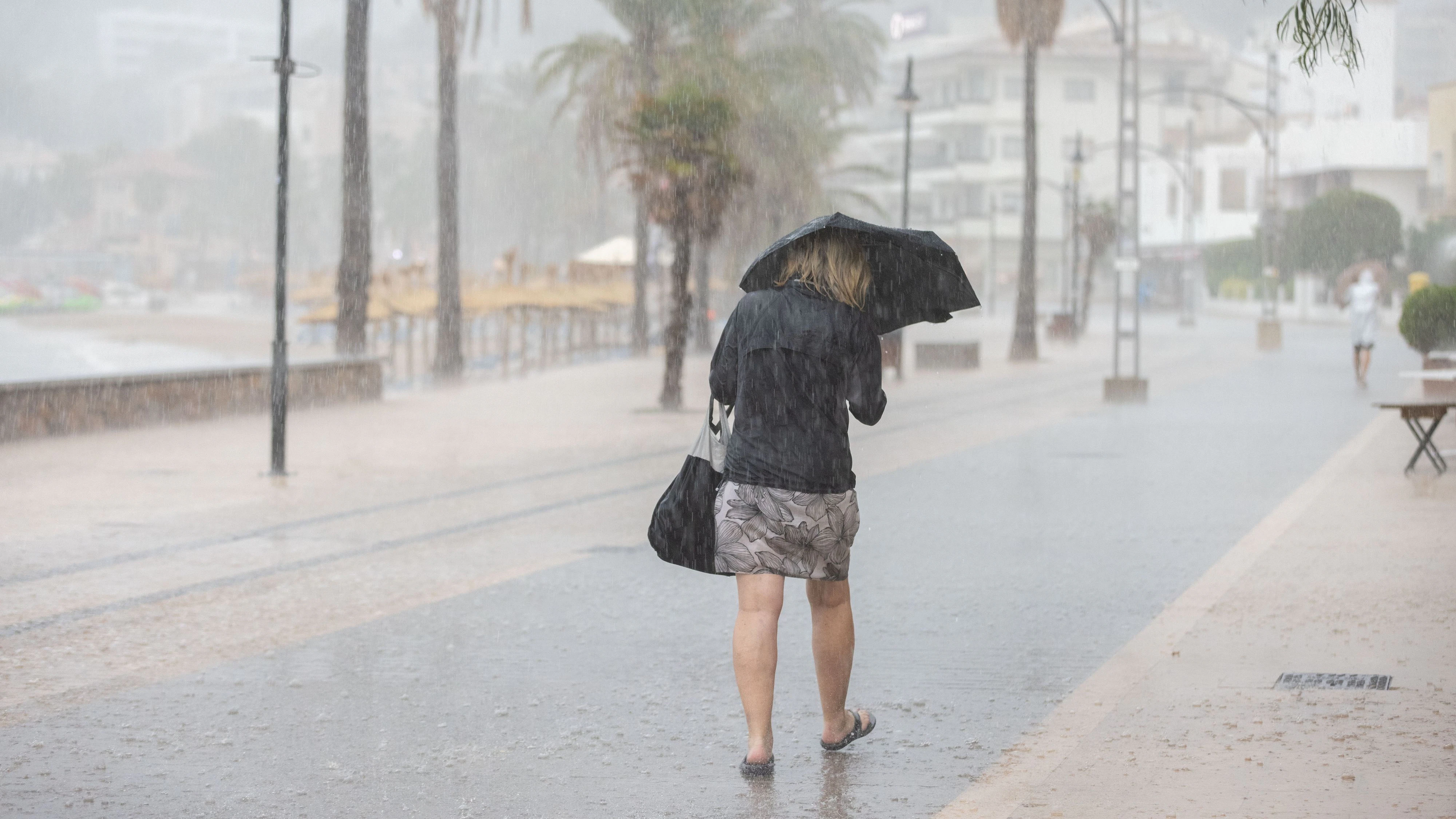 09 September 2026, Spain, Soller: People are walking in the rain in Port de Sóller. Heavy rainfall and strong winds are causing a sudden drop in temperature on the island. Photo: Clara Margais/dpa