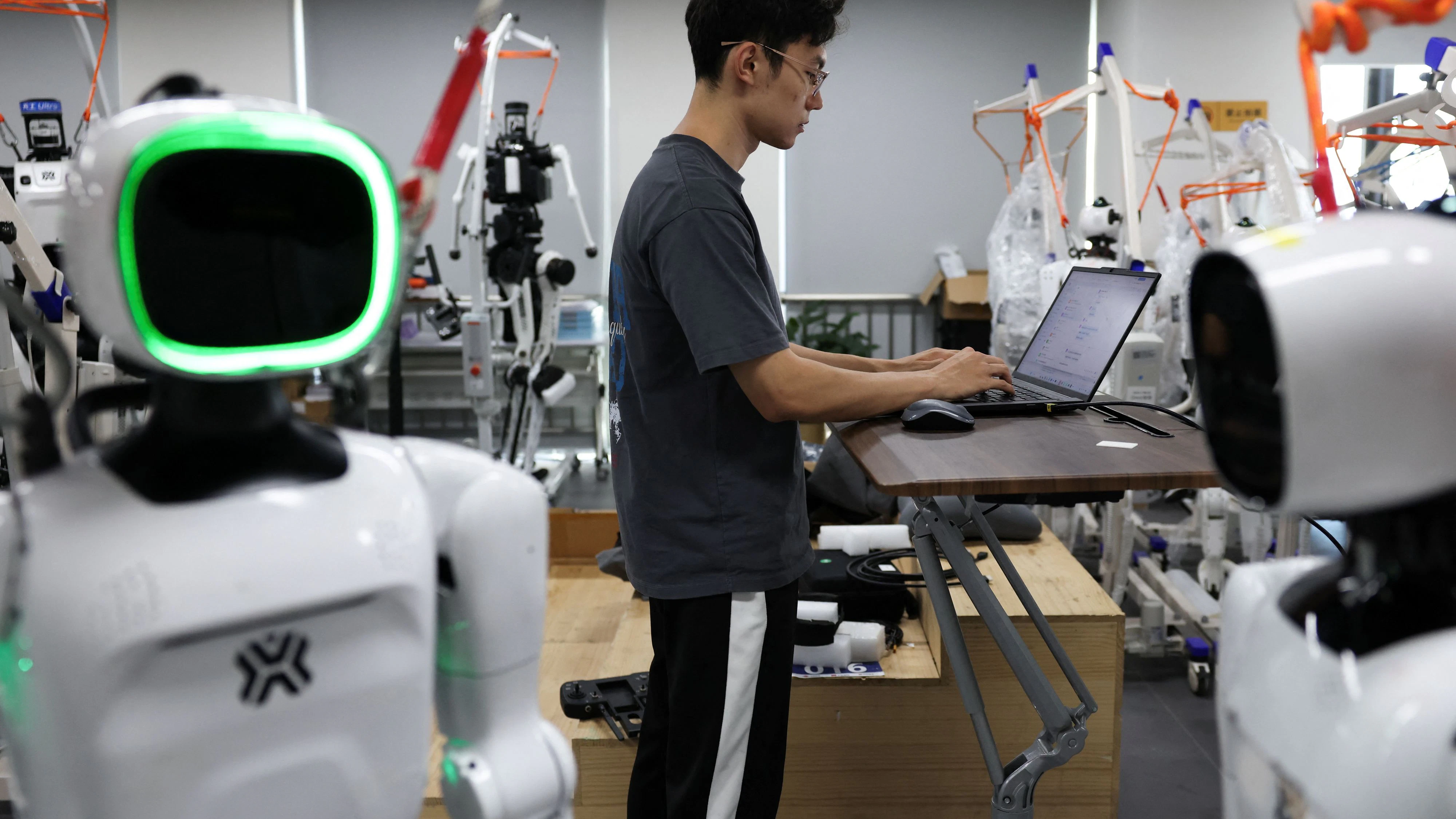 Ein Ingenieur arbeitet inmitten der humanoiden Roboter „Tiangong Omni“ und „Tiangong Ultra“ im Forschungs- und Testbereich des Beijing Humanoid Robot Innovation Center – auch bekannt als X-Humanoid – in Peking, China, am 4. September 2026.
