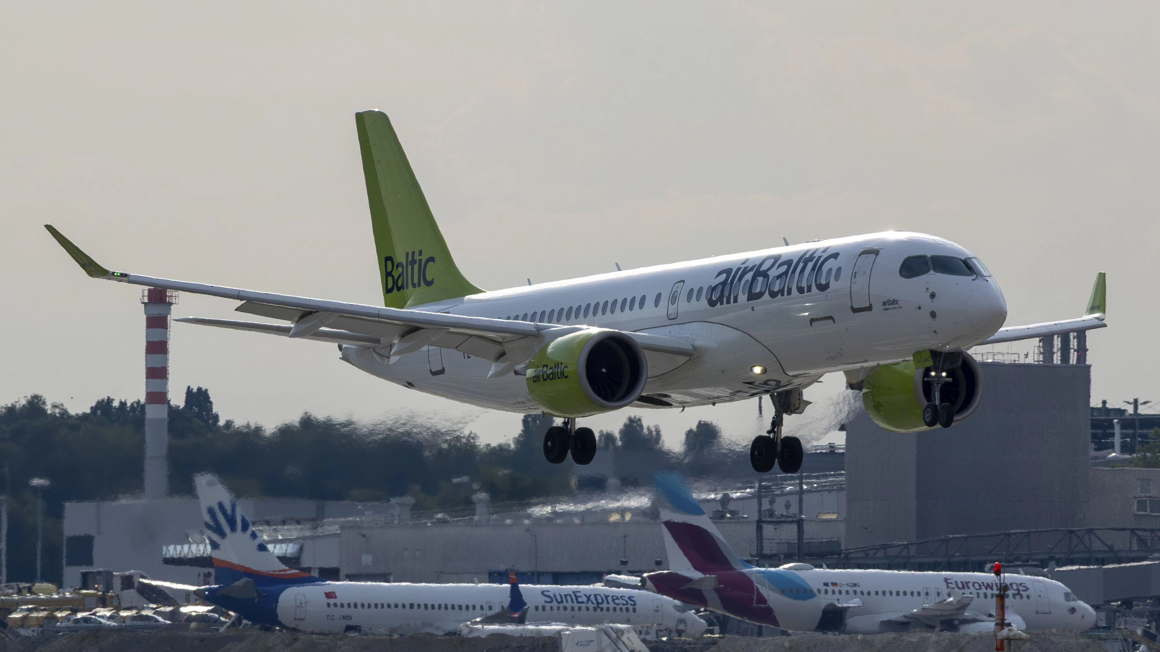 Air Baltic Airbus A220 approaching Stuttgart Airport on behalf of Austrian Airlines from Vienna. Vacation, vacation, aviation