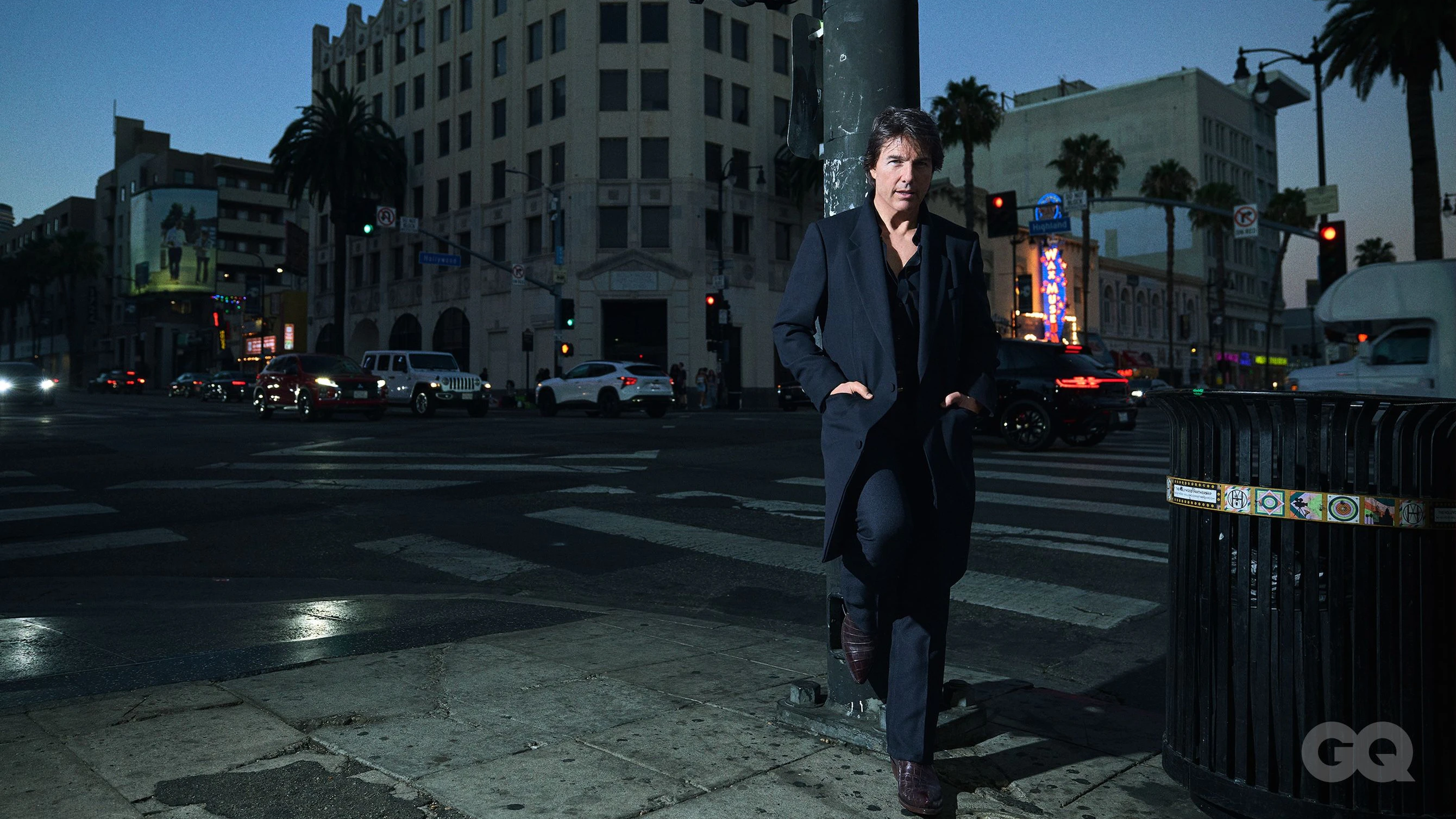Lässig lehnt Tom Cruise für das "GQ"-Shooting in einem Tom-Ford-Mantel an einer Stange.