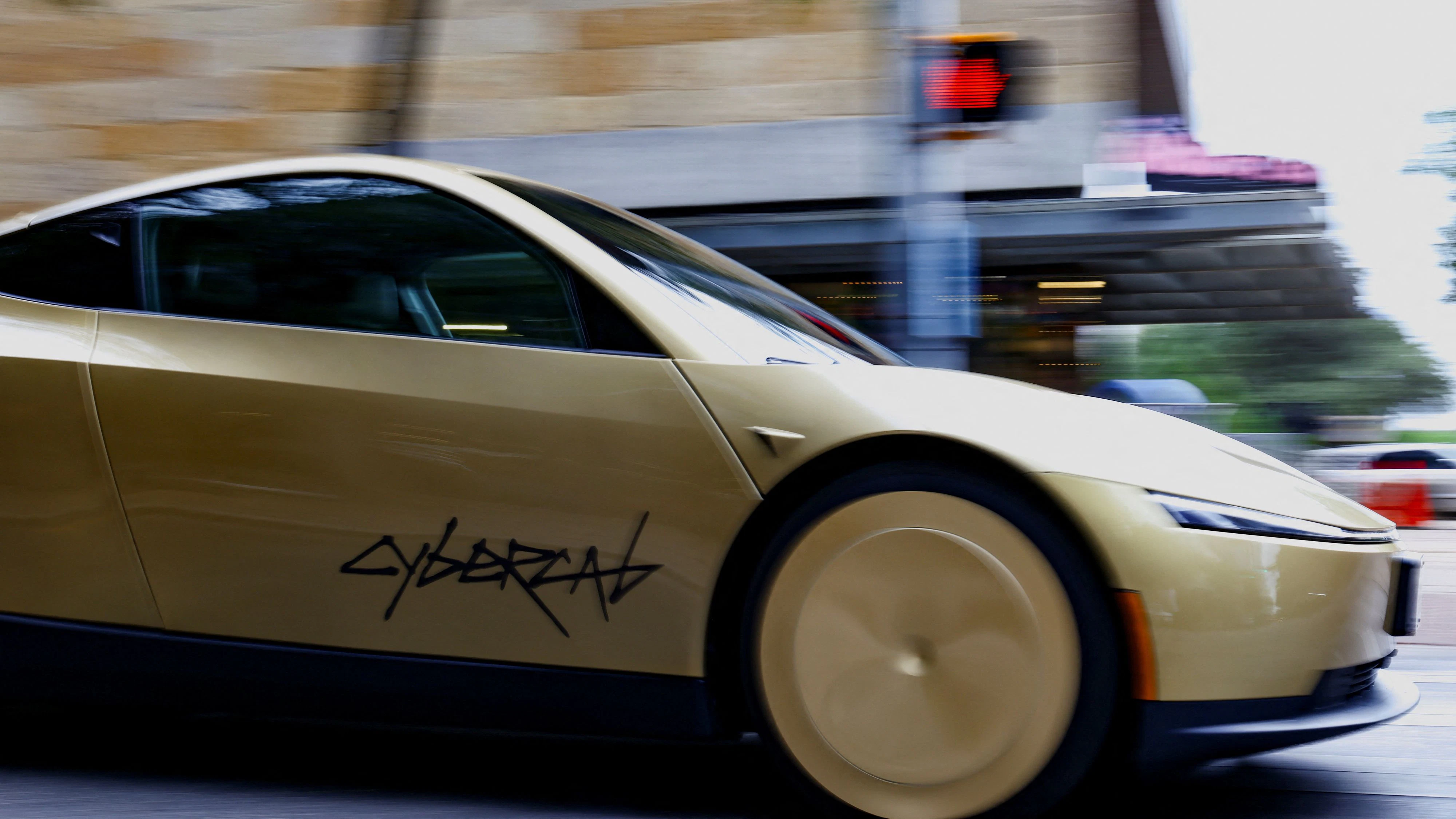 A gold-colored Tesla Cybercab arrives for an event in downtown Austin, Texas, U.S., September 3, 2026. Picture taken with a slow shutter speed. REUTERS/Kaylee Greenlee