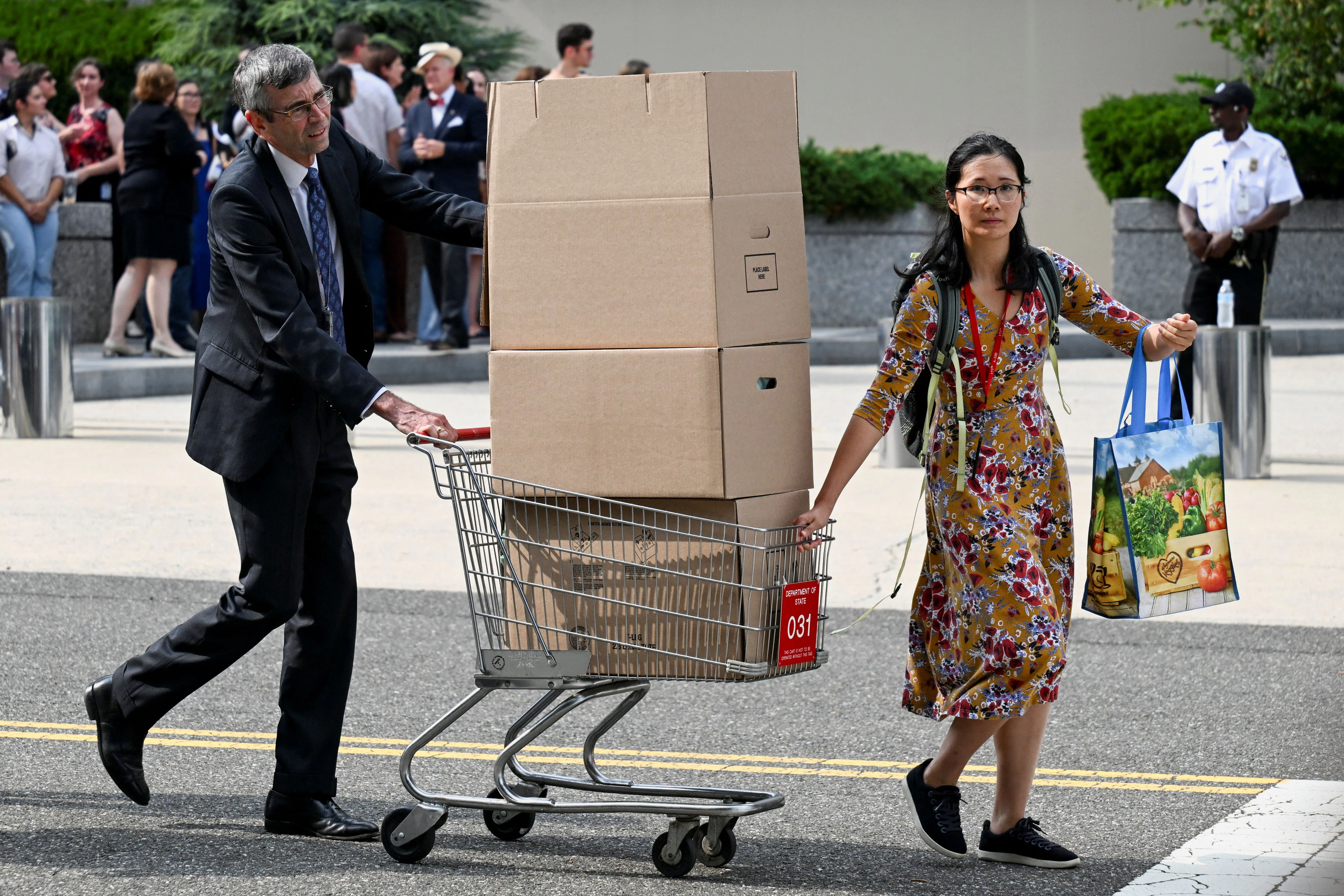 Gekündigte Mitarbeiter verlassen das State Department in Washington mit ihrem Büro-Equipment am 11. Juli 2025