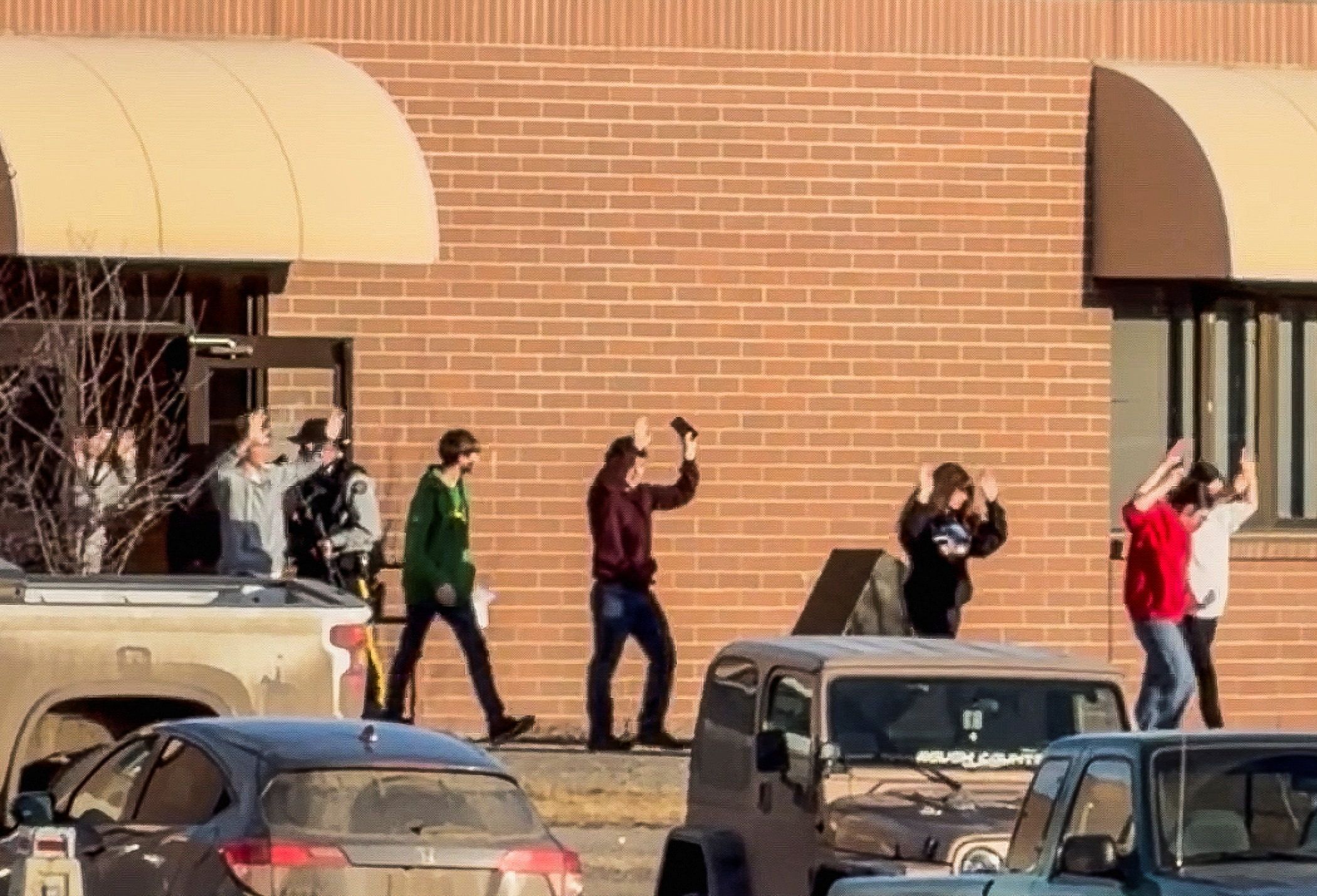 Schüler verlassen mit erhobenen Händen das Schulgebäude, nachdem die Angreiferin an einer Highschool in der Ortschaft Tumbler Ridge das Feuer eröffnet hatte.