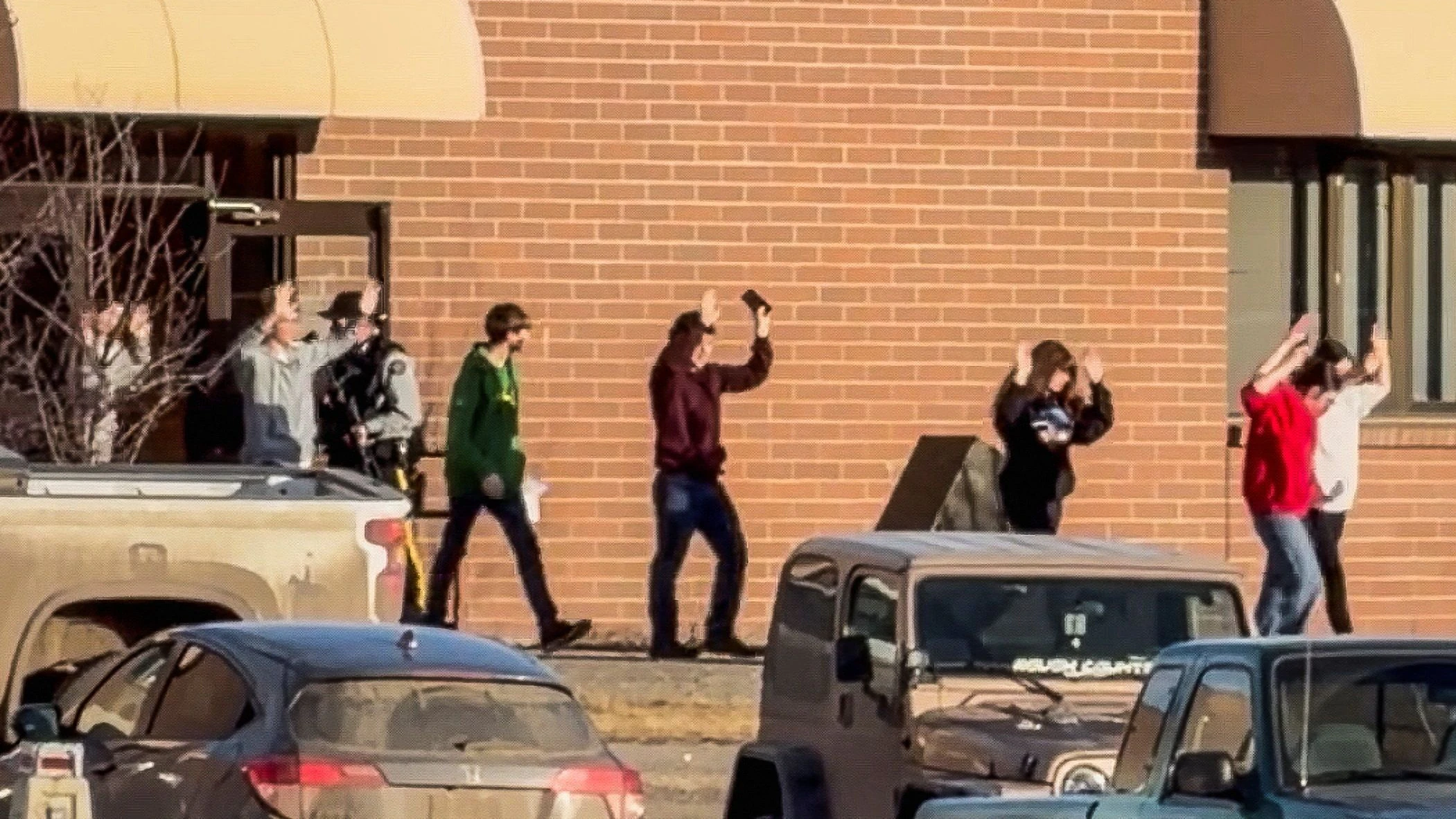 Schüler verlassen mit erhobenen Händen das Schulgebäude, nachdem die Angreiferin an einer Highschool in der Ortschaft Tumbler Ridge das Feuer eröffnet hatte.