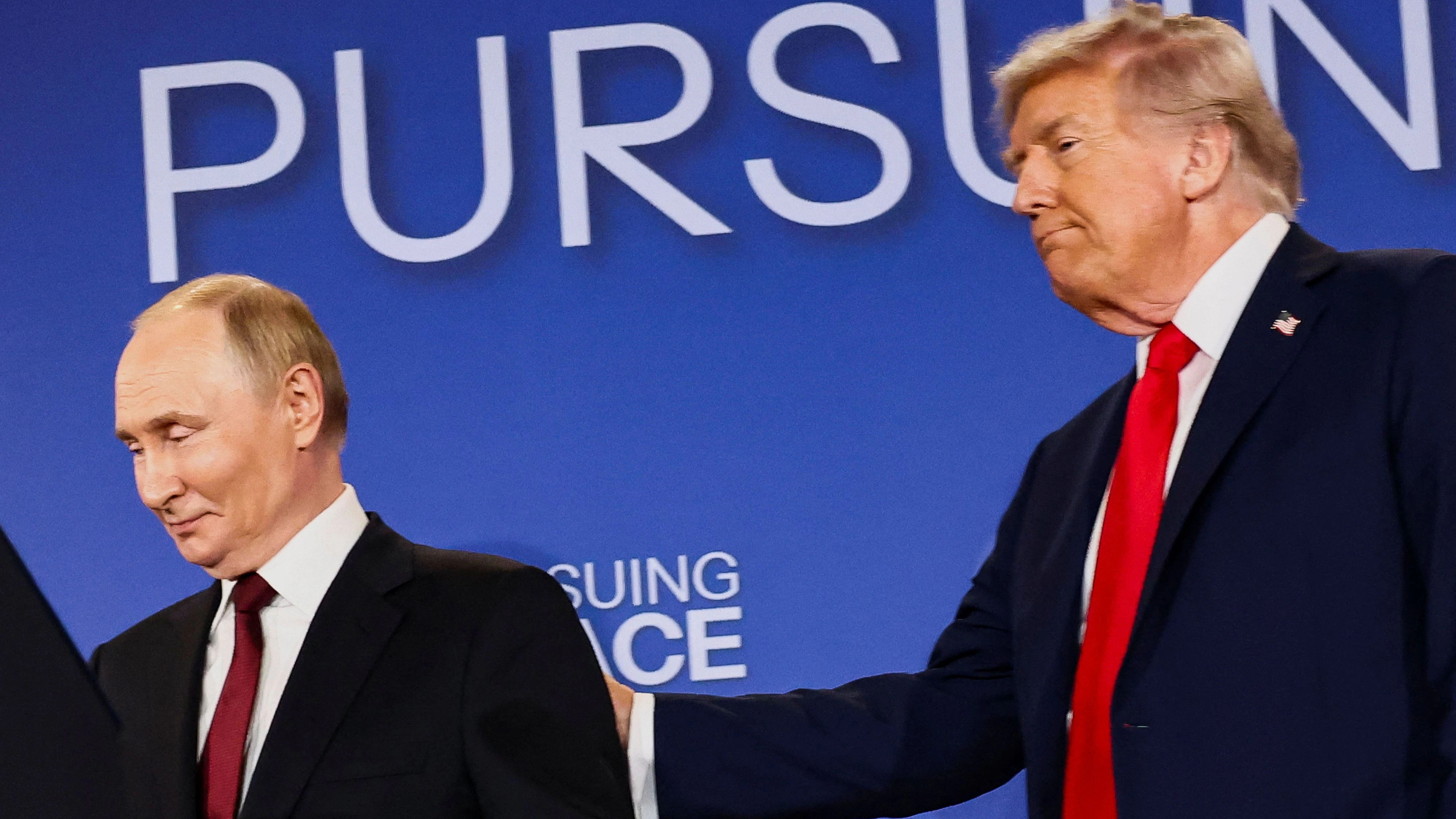 U.S. President Donald Trump holds Russian President Vladimir Putin during a press conference following their meeting to negotiate an end to the war in Ukraine, at Joint Base Elmendorf-Richardson, in Anchorage, Alaska, U.S., August 15, 2025. REUTERS/Kevin Lamarque