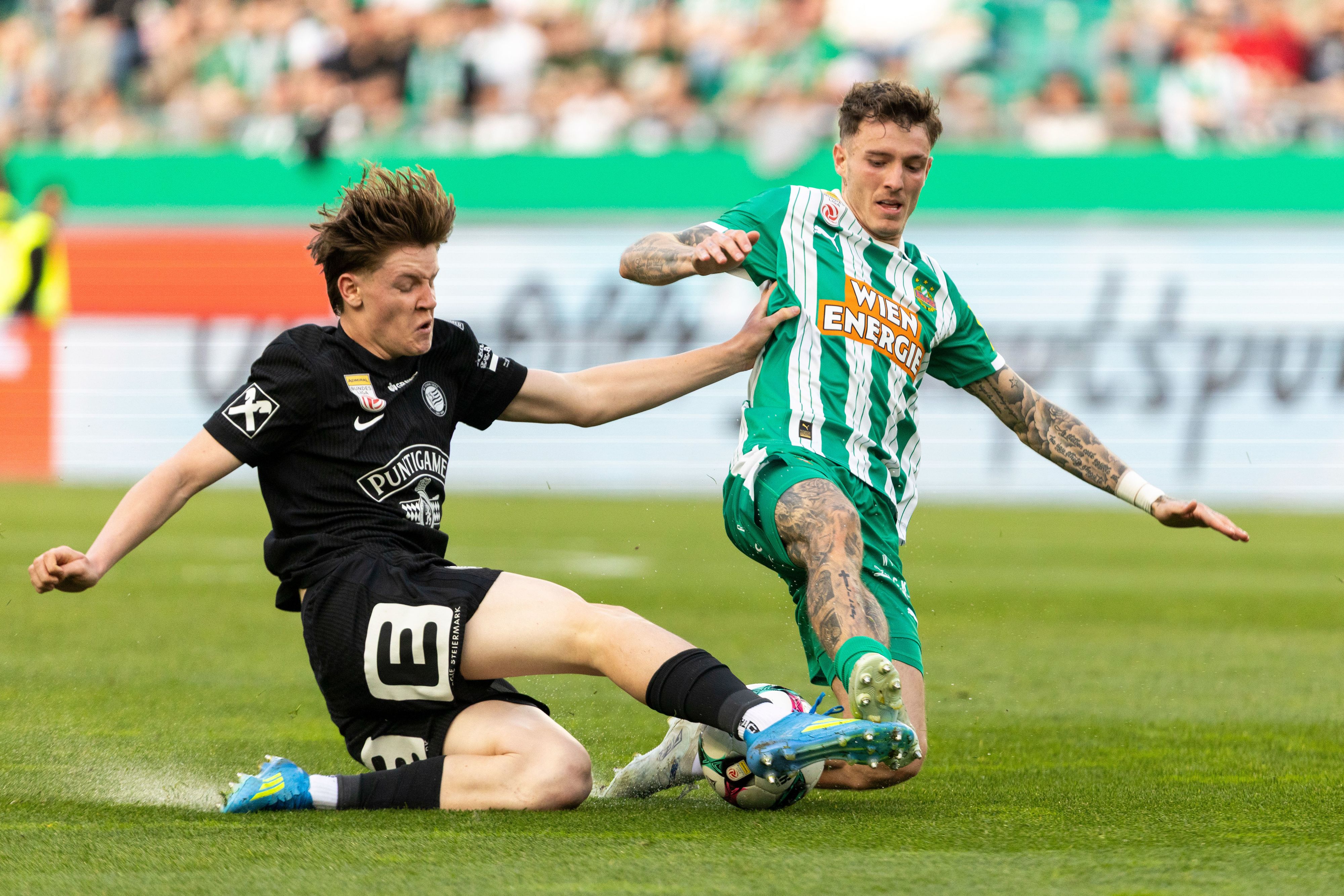 Luca Weinhandl (Sturm) im Zweikampf mit Bendeguz Bolla von Rapid.