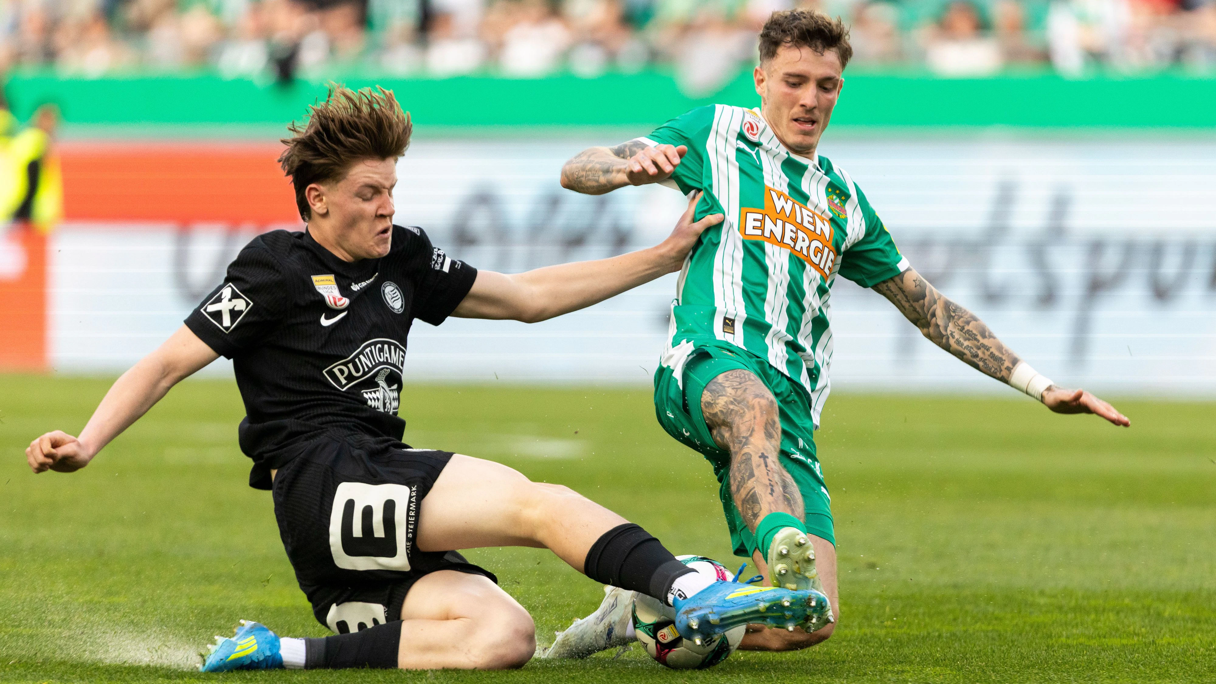 Luca Weinhandl (Sturm) im Zweikampf mit Bendeguz Bolla von Rapid.