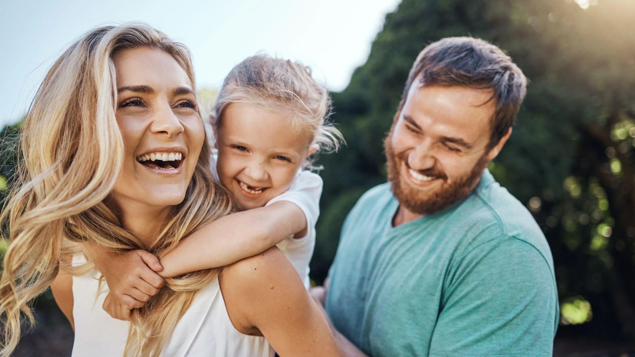Liebe, eine glückliche Familie und die Natur im Sommer – junge Eltern verbringen gemeinsam Zeit mit ihrem Kind.