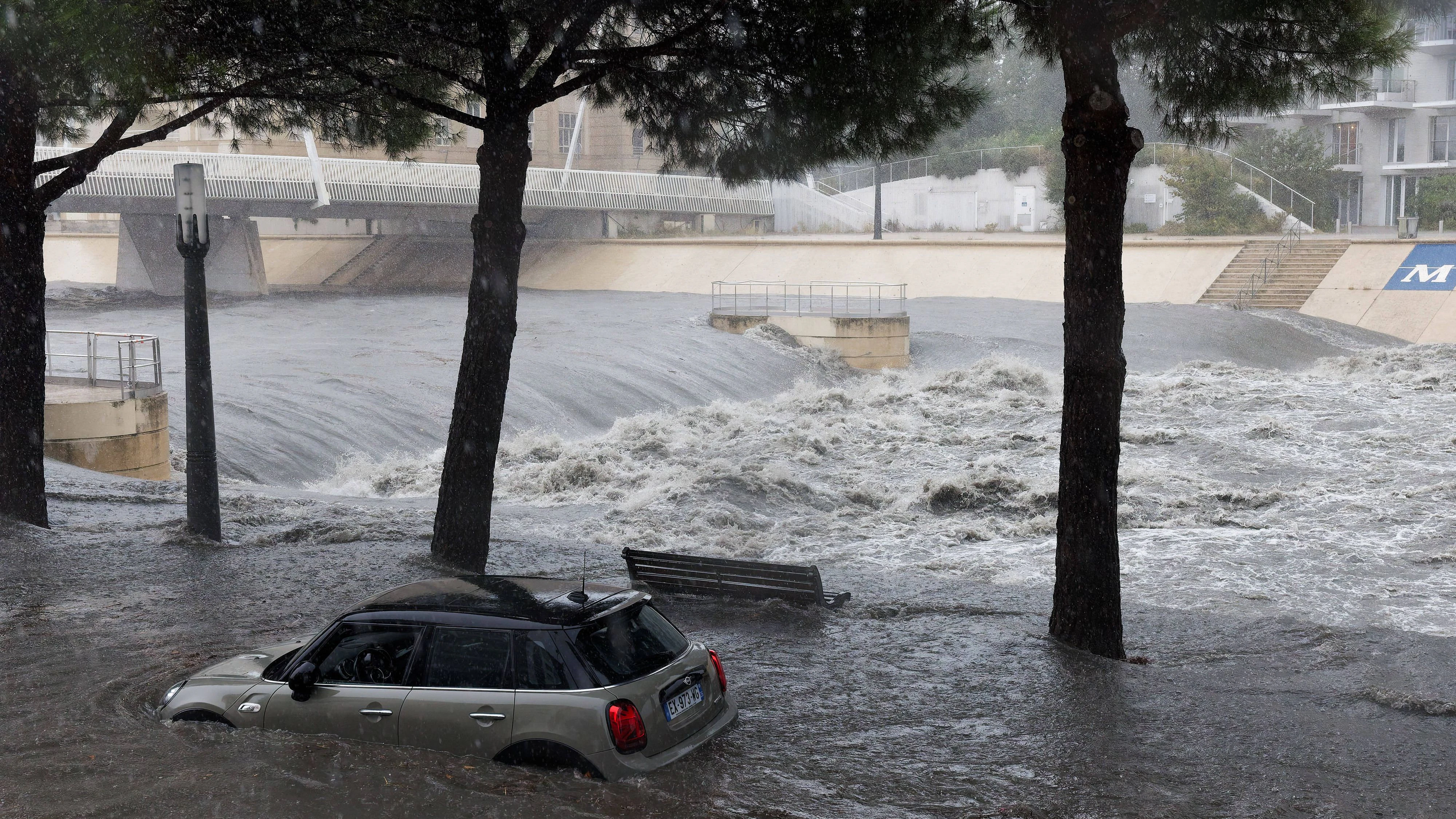 Ein Auto steht teilweise im Wasser in einem überfluteten Gebiet in der Nähe des Flusses Lez, wo das Wasser sehr unruhig ist, in Montpellier während des Mittelmeersturms am 30. September 2026.