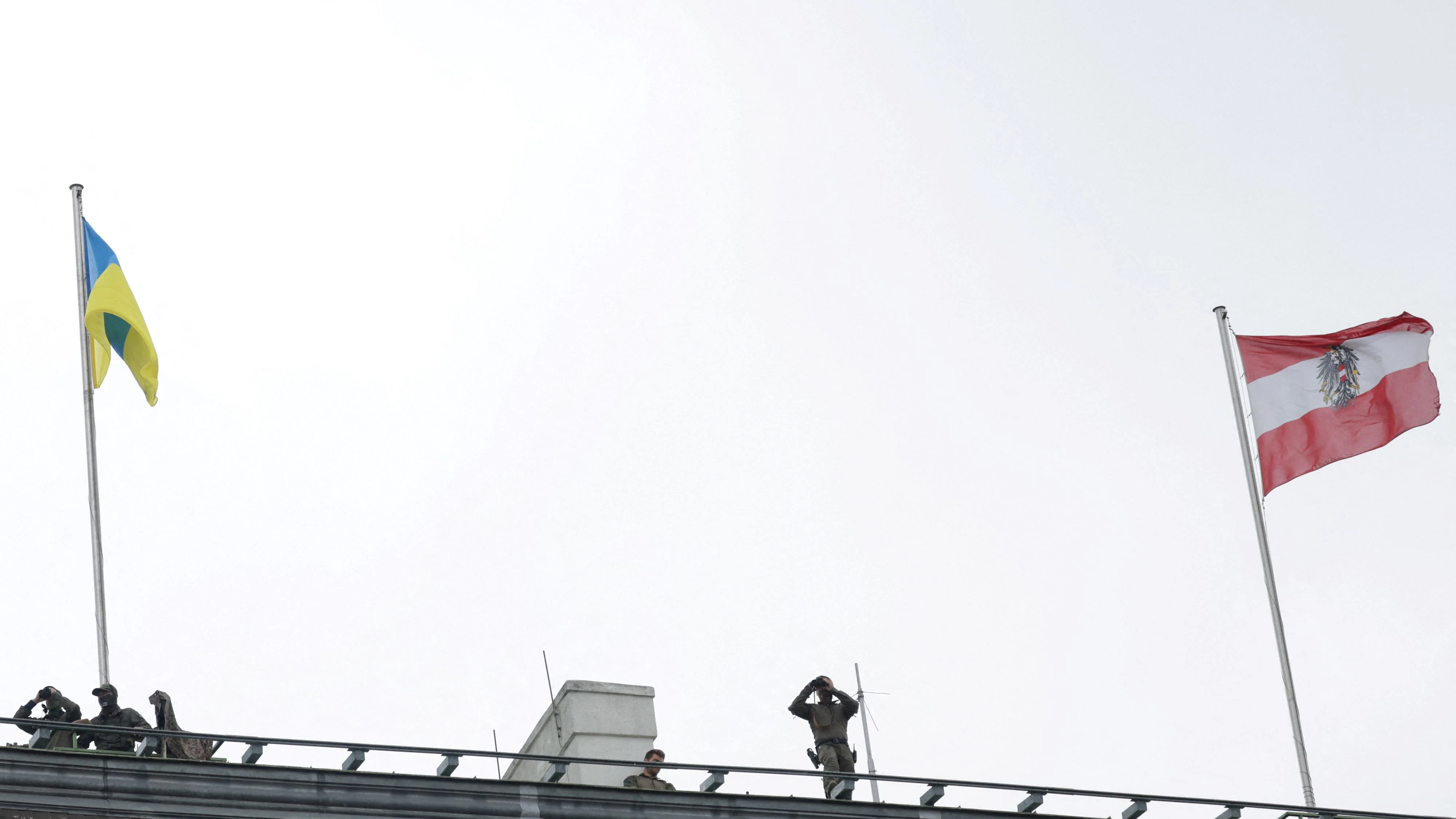 Members of the Austrian armed forces stand on the rooftop of the Chancellery as the Ukrainian and Austrian flags fly, on the day of Ukrainian President Volodymyr Zelenskiy's visit, in Vienna, Austria June 16, 2025. REUTERS/Leonhard Foeger 