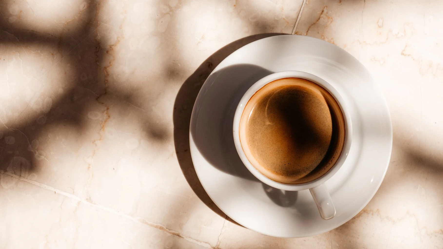 Cup of aromatic coffee standing on an empty table. View from above, outdoor, close-up. Vacation and travel concept