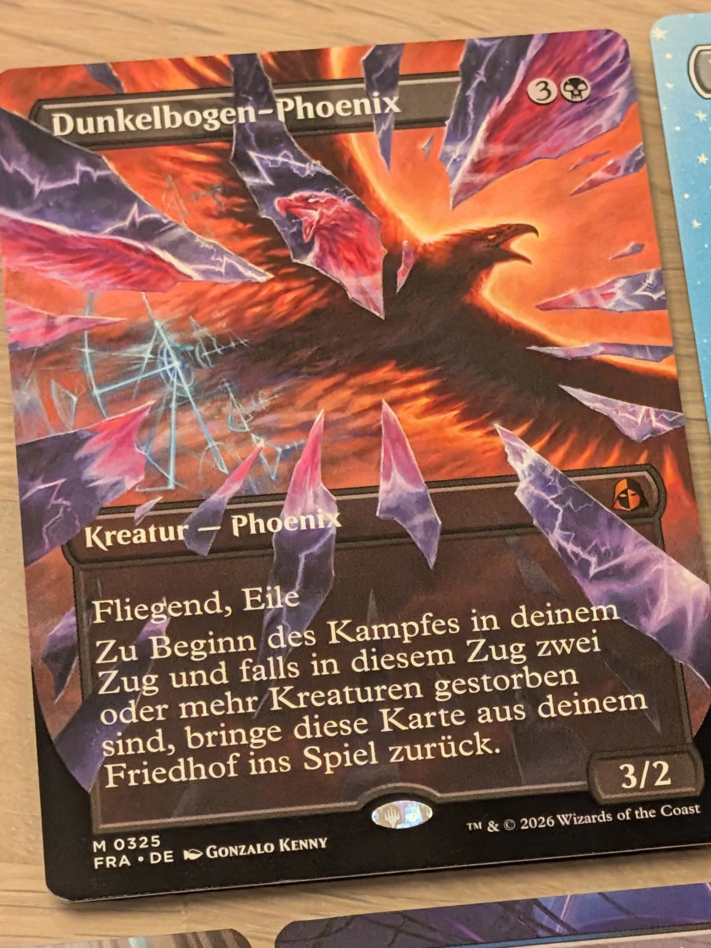 "Dunkelbogen-Phoenix" als Zersplitterter-Spiegel-Karte aus dem Echoversum. Seine Vorlage, "Lichtbogen-Phoenix", aus dem echten Multiversum ist auf den Scherben angedeutet.
