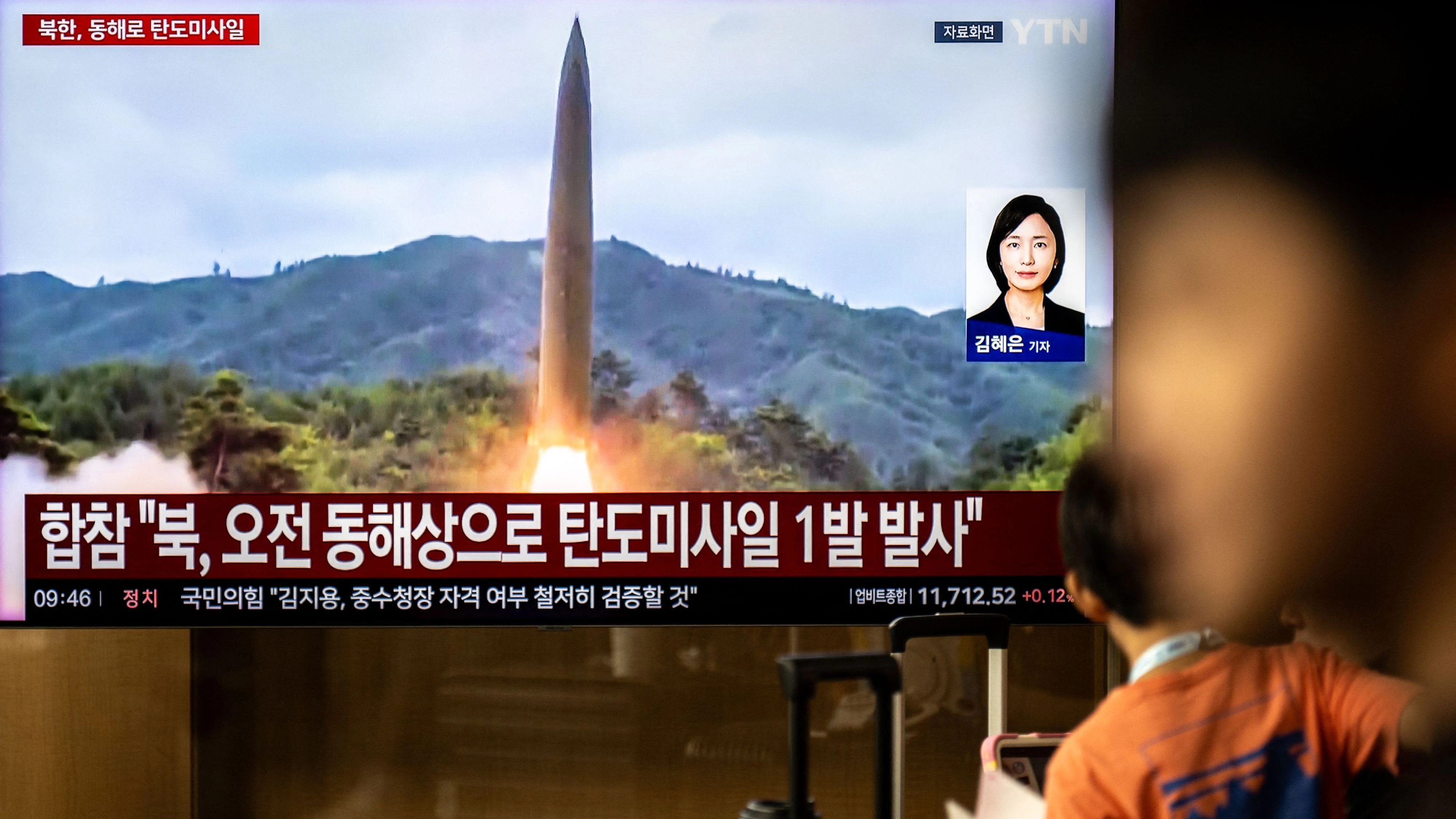 News coverage showing file footage of a North Korean missile launch is seen on a screen at Seoul Station in Seoul on October 3, 2026. North Korea fired at least one ballistic missile, Seoul's military said after it blamed the North for an explosion in the Demilitarised Zone that wounded three South Korean soldiers. (Photo by Philip FONG / AFP)