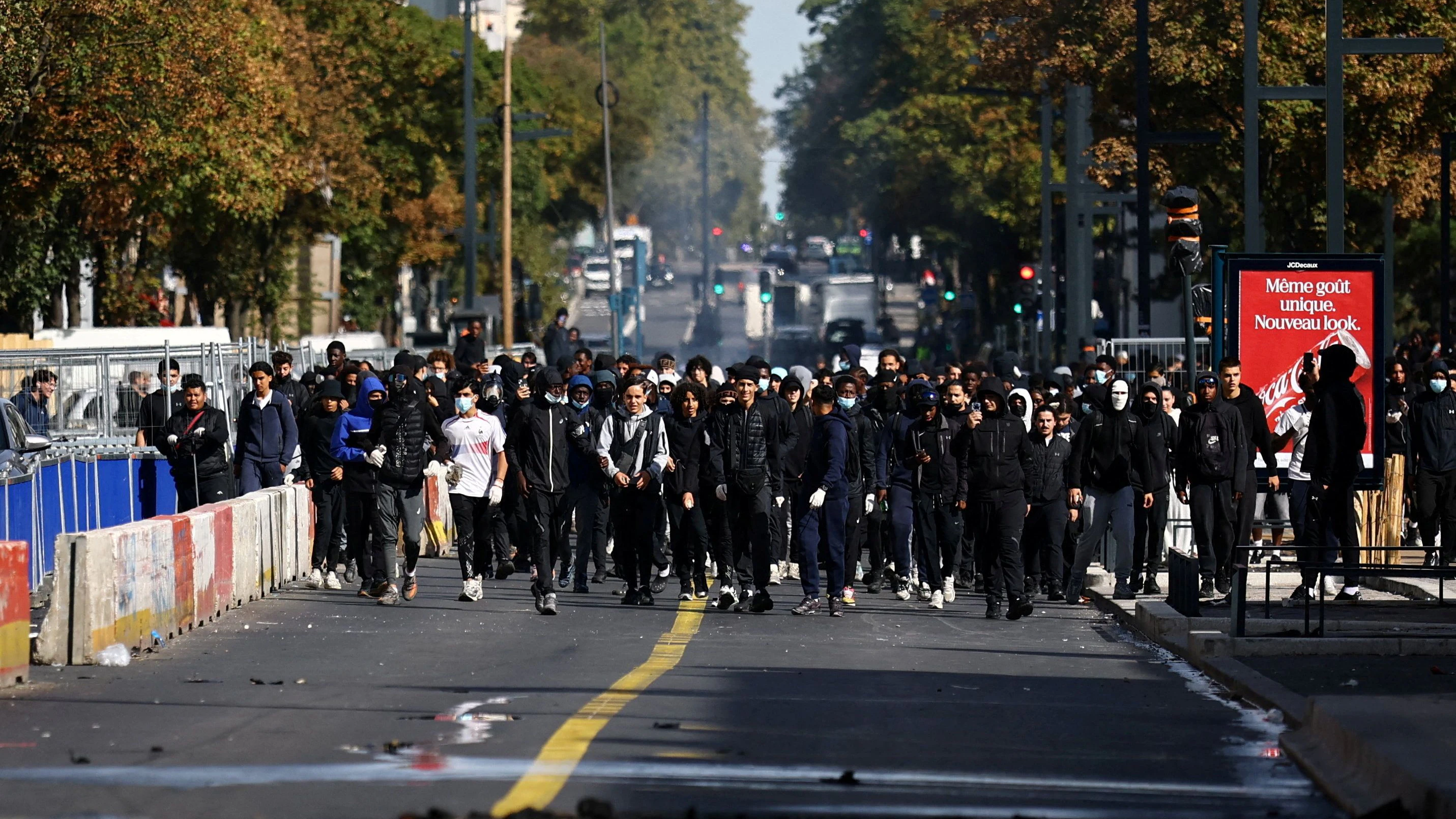 FILE PHOTO: Masked protesters react in a street amid clashes during a protest by high school students near the Lycee Berthelot high school in Aubervilliers near Paris as part of nationwide protests to demand the hiring of substitute teachers, increased resources and better learning conditions, as more than 400 schools remain closed following days of student protests that have escalated into violence in some places, France, October 2, 2026.  REUTERS/Sarah Meyssonnier/File Photo