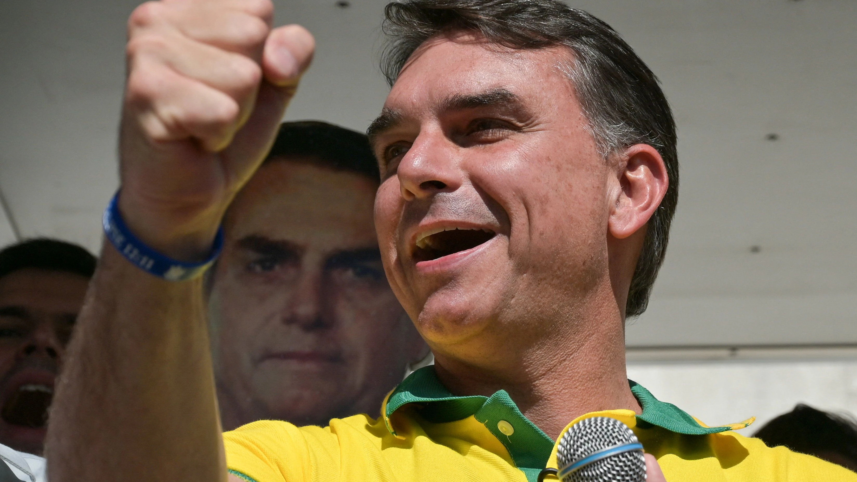 Brazilian presidential candidate and senator Flavio Bolsonaro gestures in front of a placard of his father, former President of Brazil Jair Bolsonaro, as he attends an election campaign in Belo Horizonte, Brazil, August 18, 2026. REUTERS/Washington Alves