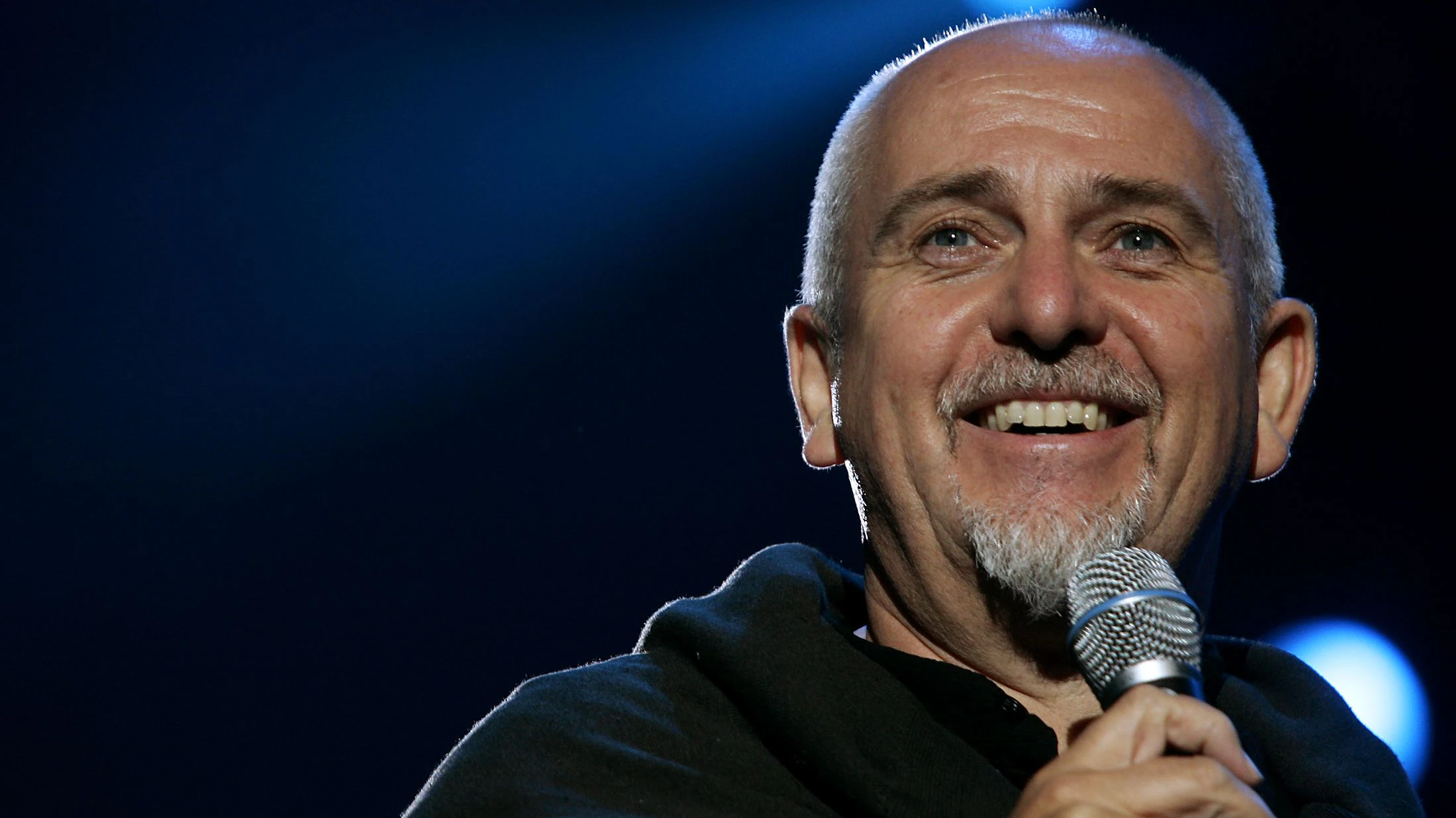 British musician Peter Gabriel smiles during the Africa Calling Live 8 concert at the Eden Project in Cornwall.  British musician Peter Gabriel smiles during the Africa Calling Live 8 concert, at the Eden Project in Cornwall, July 2, 2005. A galaxy of rock and roll stars will grace stages across the globe on Saturday for what is being billed as the greatest music show ever, in a bid to put pressure on leaders of the Group of Eight major industrialised nations meeting in Scotland next week to do more to alleviate poverty, particularly in Africa. Live 8, an expanded version of the Live Aid sensation 20 years ago, will take in 10 cities and four continents, kicking off in Tokyo in the east and ending in North America in the west. REUTERS/Stoyan Nenov