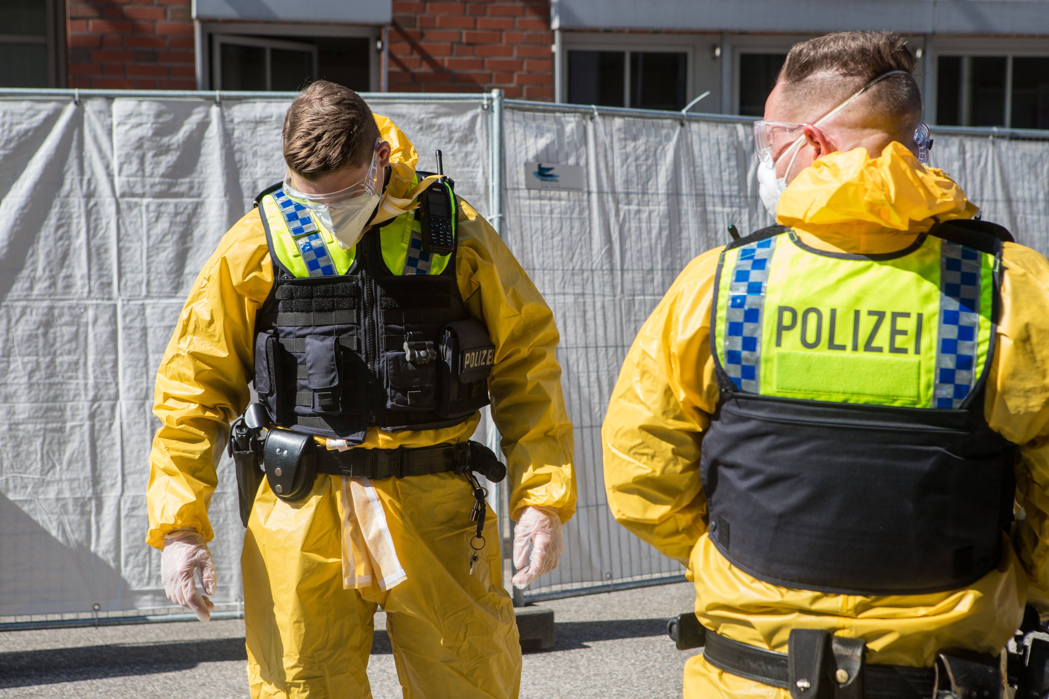 Deutsche Polizisten in Schutzanzügen. 