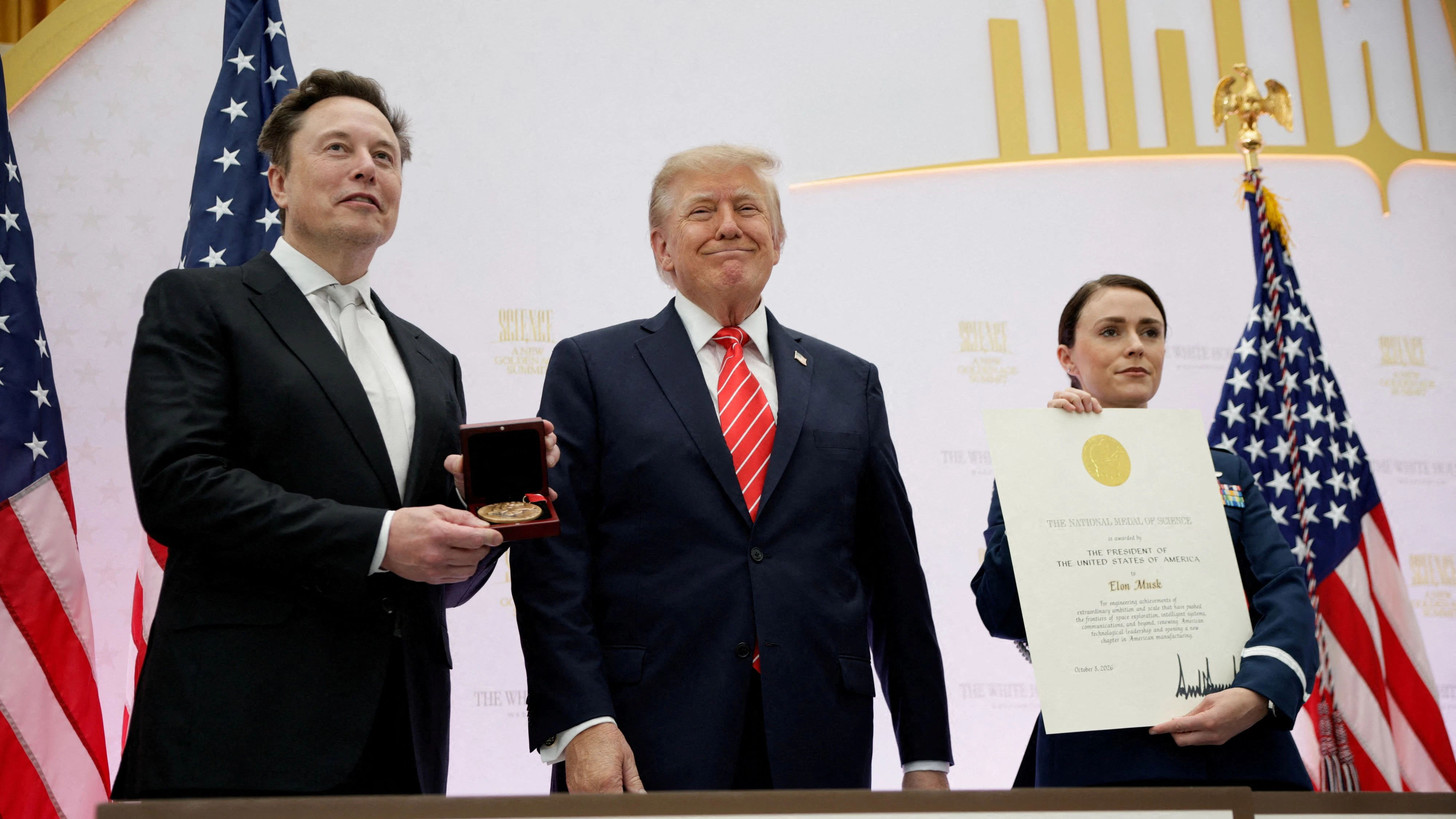 US President Donald Trump presents the National Medal of Science and SpaceX CEO Elon Musk during the "A New Golden Age" summit at the U.S. Institute of Peace, renamed The Donald J. Trump Institute of Peace by the Trump administration, in Washington, DC, US, October 8, 2026. REUTERS/Evan Vucci   REFILE - CORRECTING FROM "NATIONAL MEDAL OF TECHNOLOGY AND INNOVATION" TO "NATIONAL MEDAL OF SCIENCE".