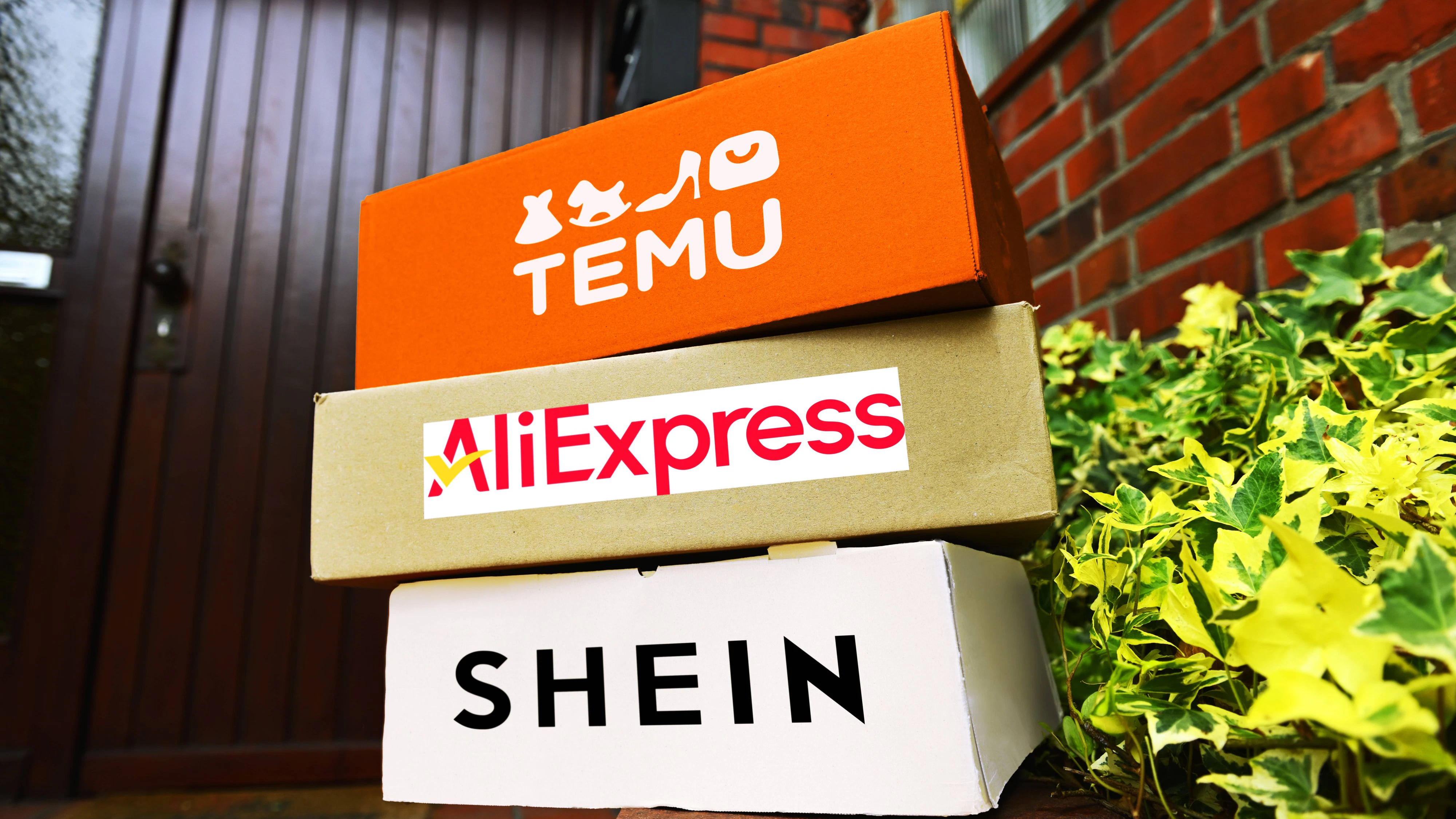 FOTOMONTAGE, Gestapelte Pakete von den chinesischen Versandhändlern Temu, AliExpress und Shein in einem Hauseingang *** FOTOMONTAGE, Stacked parcels from the Chinese mail order companies Temu, AliExpress and Shein in a building entrance