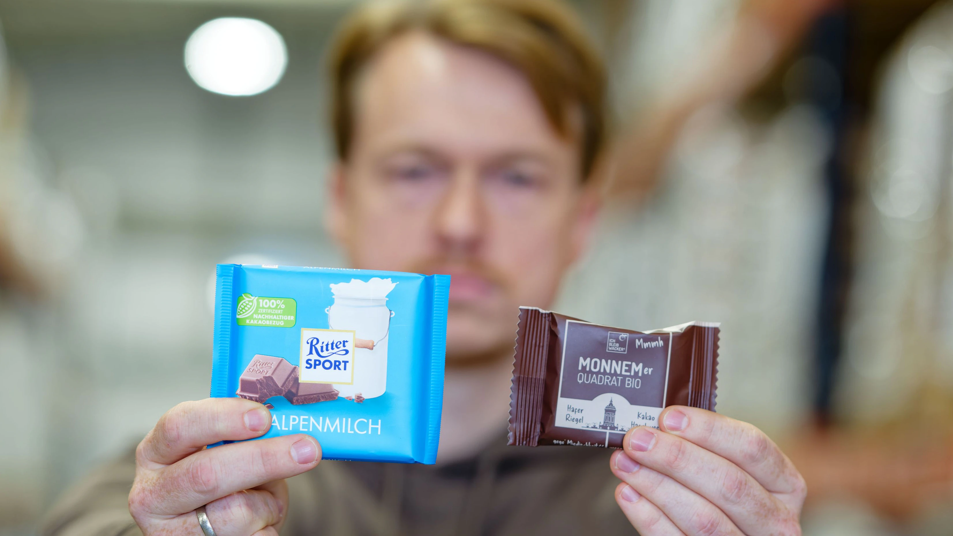 Streit ums Quadrat: Matteo Wacker, Eigentümer und Gründer von Wacker, mit einer Ritter-Sport-Schoko und dem eigenen Haferriegel "Monnemer Quadrat Bio".