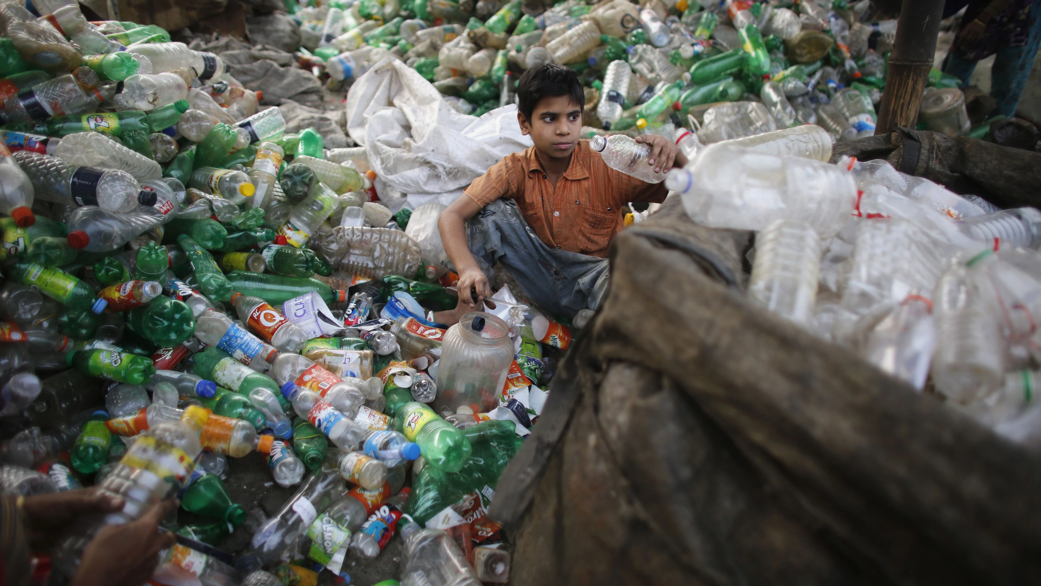 A boy works at a plastic bottle recycling centre by the river Buriganga in Dhaka January 7, 2014. REUTERS/Andrew Biraj (BANGLADESH - Tags: SOCIETY)
