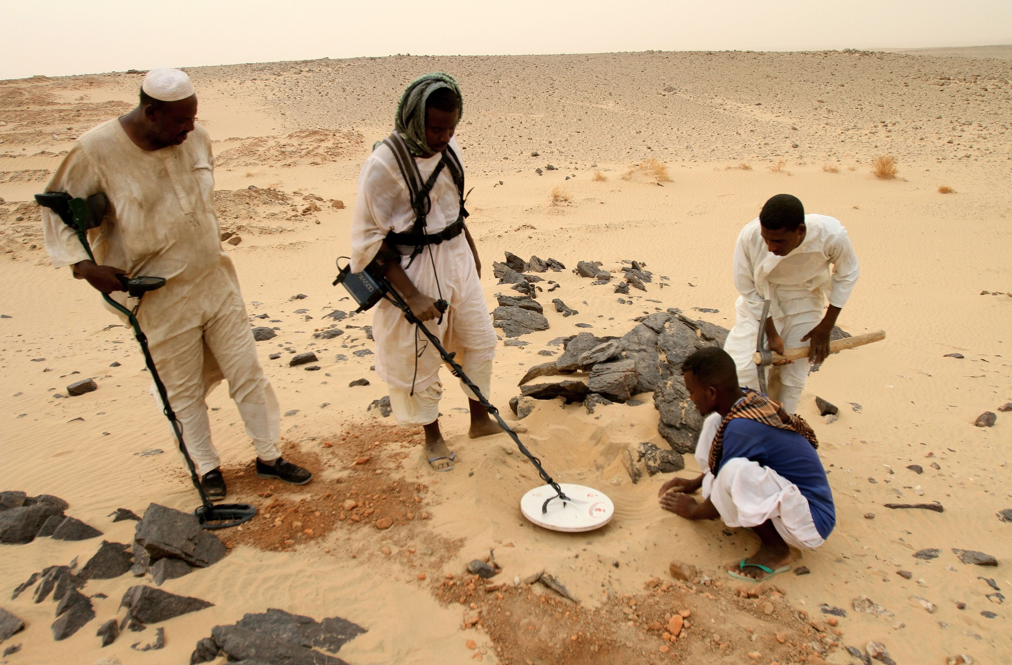 Sudanesische Männer suchen in der Wüste im Norden des Sudans mit Metalldetektoren nach Gold. Steigende Goldpreise in Verbindung mit der Verfügbarkeit von Metalldetektoren haben schon in den späten 2000er Jahren einen Goldrausch ausgelöst. Tausende Glücksritter strömten seither jedes Jahr in die Region.