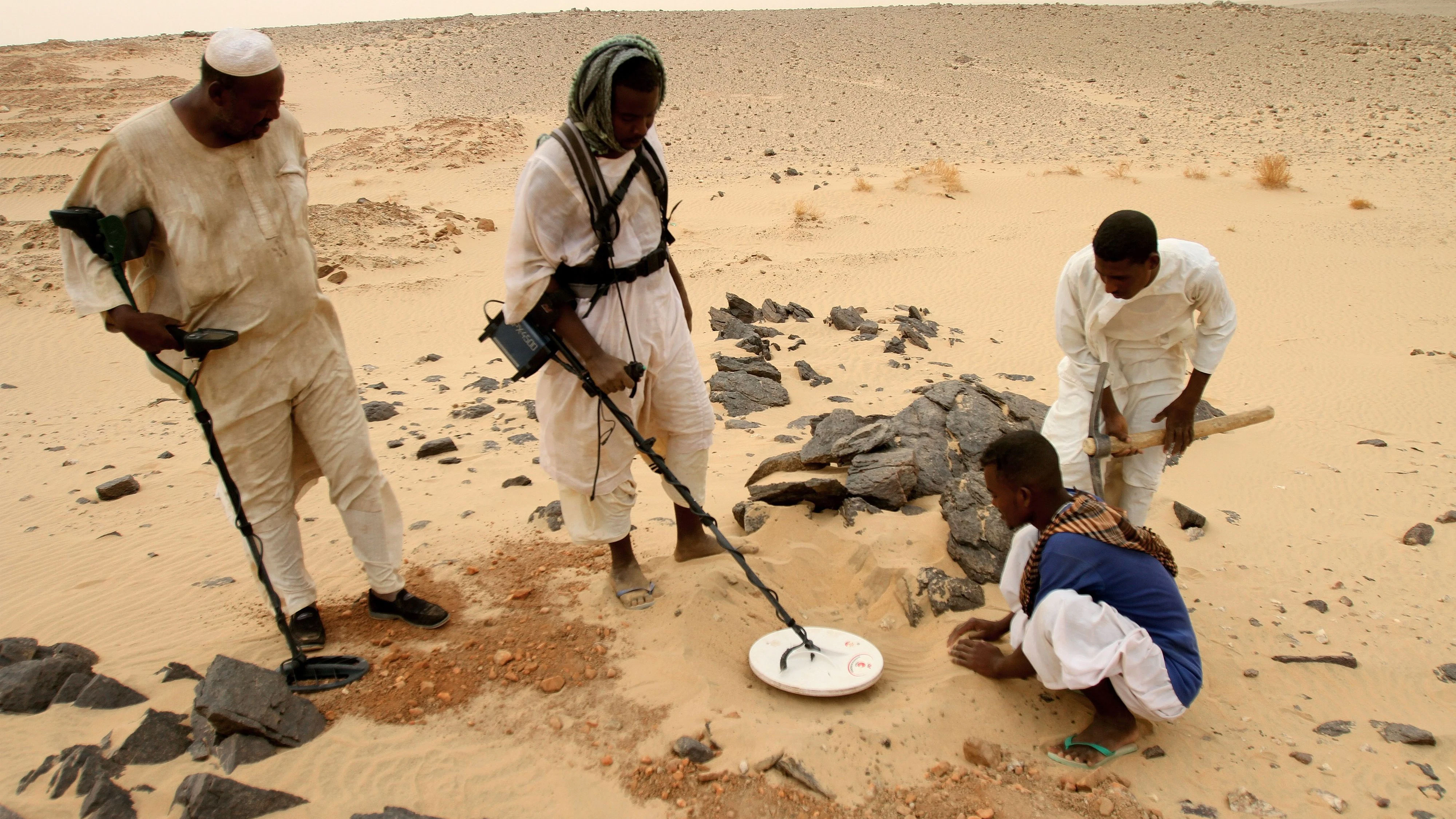 Sudanesische Männer suchen am 8. August 2010 in der Wüste nahe dem Dorf al-Shirik im Norden des Sudans mit Metalldetektoren nach Gold. Steigende Goldpreise in Verbindung mit der Verfügbarkeit von Metalldetektoren haben im Norden des Sudans einen Goldrausch ausgelöst, sodass in den letzten Jahren Tausende von Goldsuchern in die Region strömten, in der Hoffnung, das große Glück zu machen.