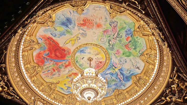 Seit 60 Jahren verdeckt ein farbenprächtiges und mittlerweile weltberühmtes Deckengemälde von Marc Chagall das klassische Original in der Pariser Oper, dem Palais Garnier. Jetzt fordert ein Nachkomme des ursprünglichen Künstlers vor Gericht dessen Freilegung.