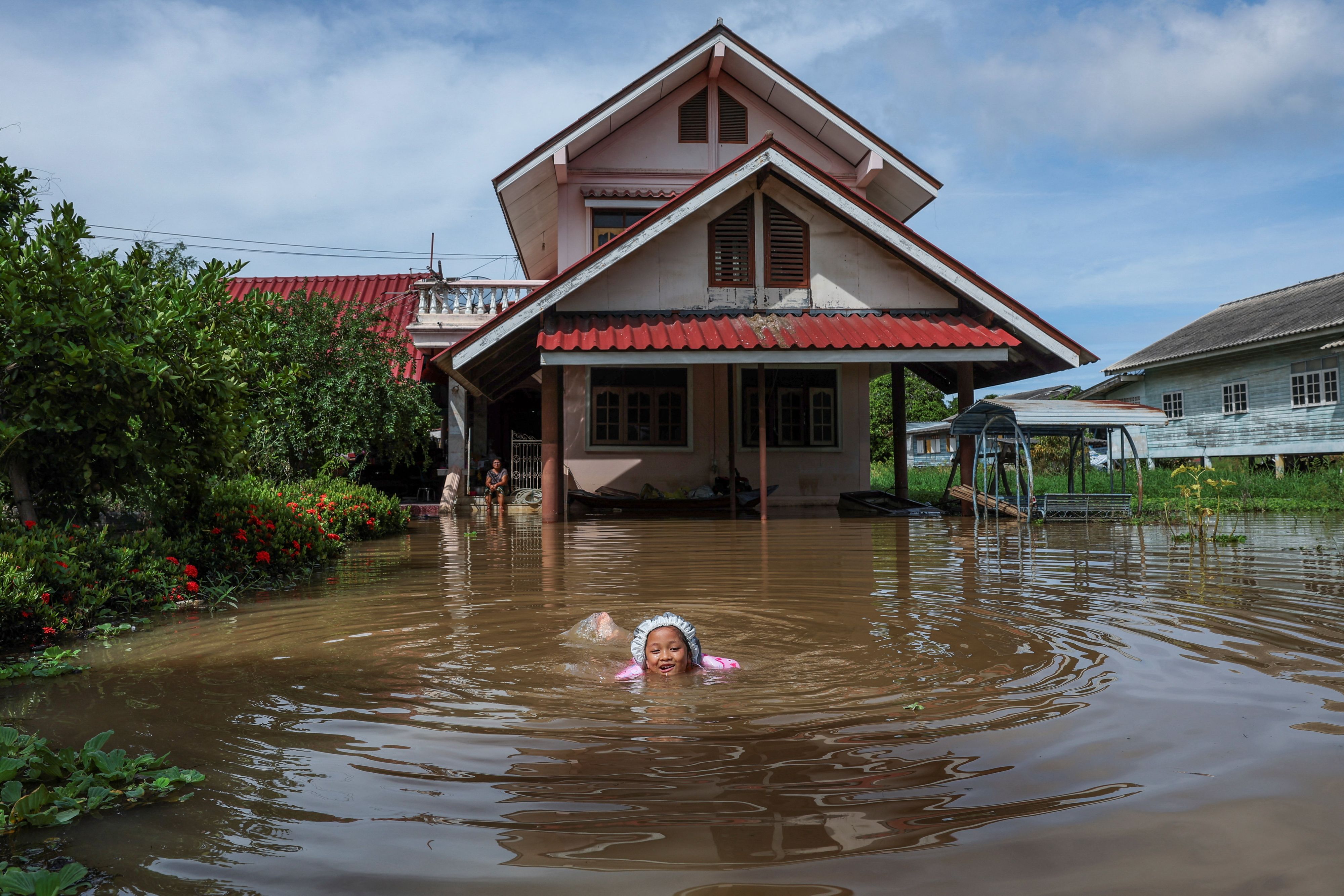 Die fünfjährige Nichakorn Sri-ampai schwimmt durch ein überflutetes Gebiet vor ihrem Haus im Bezirk Sena (Provinz Ayutthaya, Thailand).