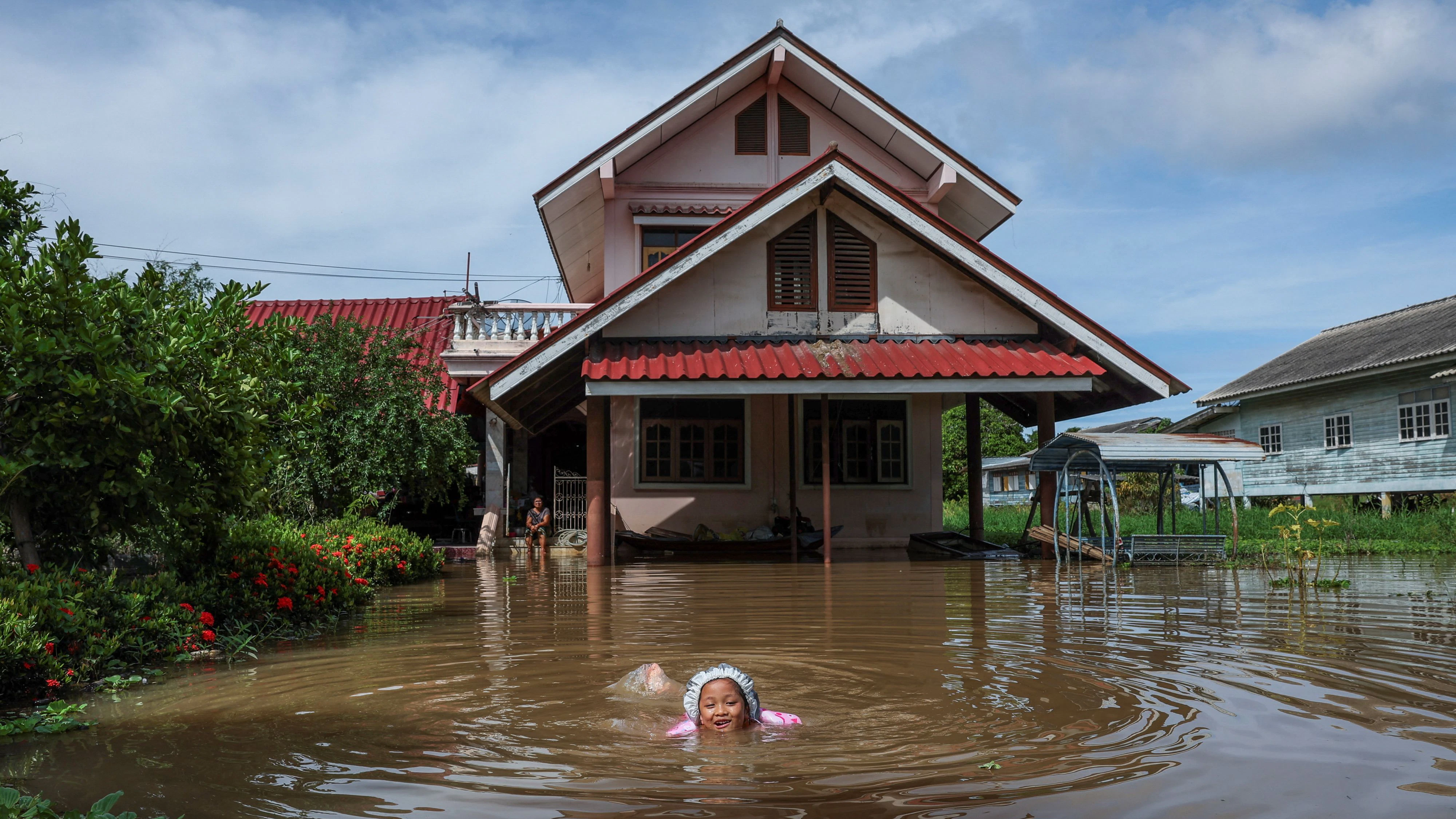 Nichakorn Sri-ampai, 5, swims through a flooded area outside her home, affected by heavy rainfall and overflowing rivers, with Ayutthaya as one of the worst-hit areas, at Sena district, in Ayutthaya province, Thailand, October 8, 2025. REUTERS/Chalinee Thirasupa