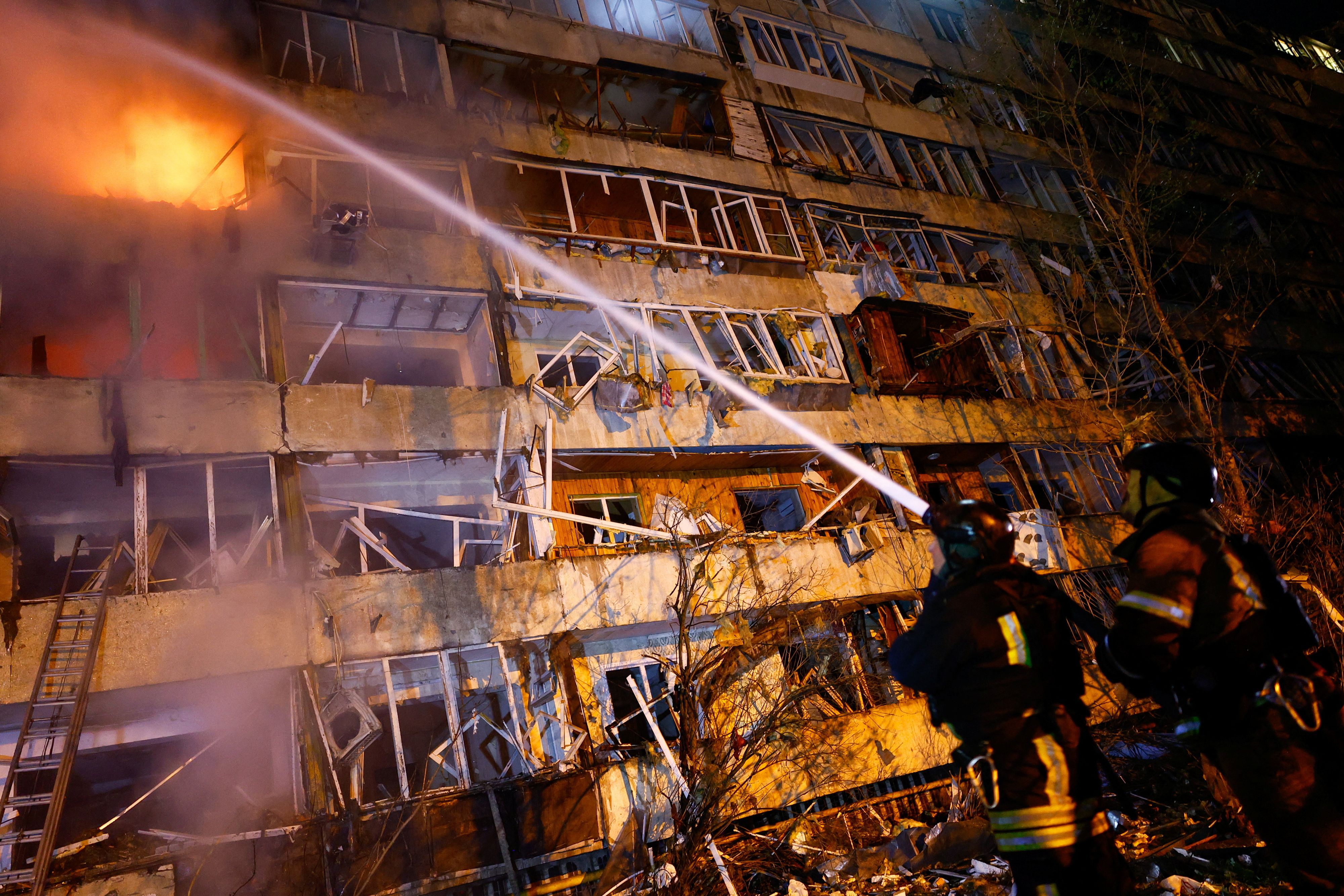 Feuerwehrleute löschen in Kiew ein nach einem russischen Raketenangriff brennendes Wohnhaus in der Nacht auf den 14. Oktober 2026