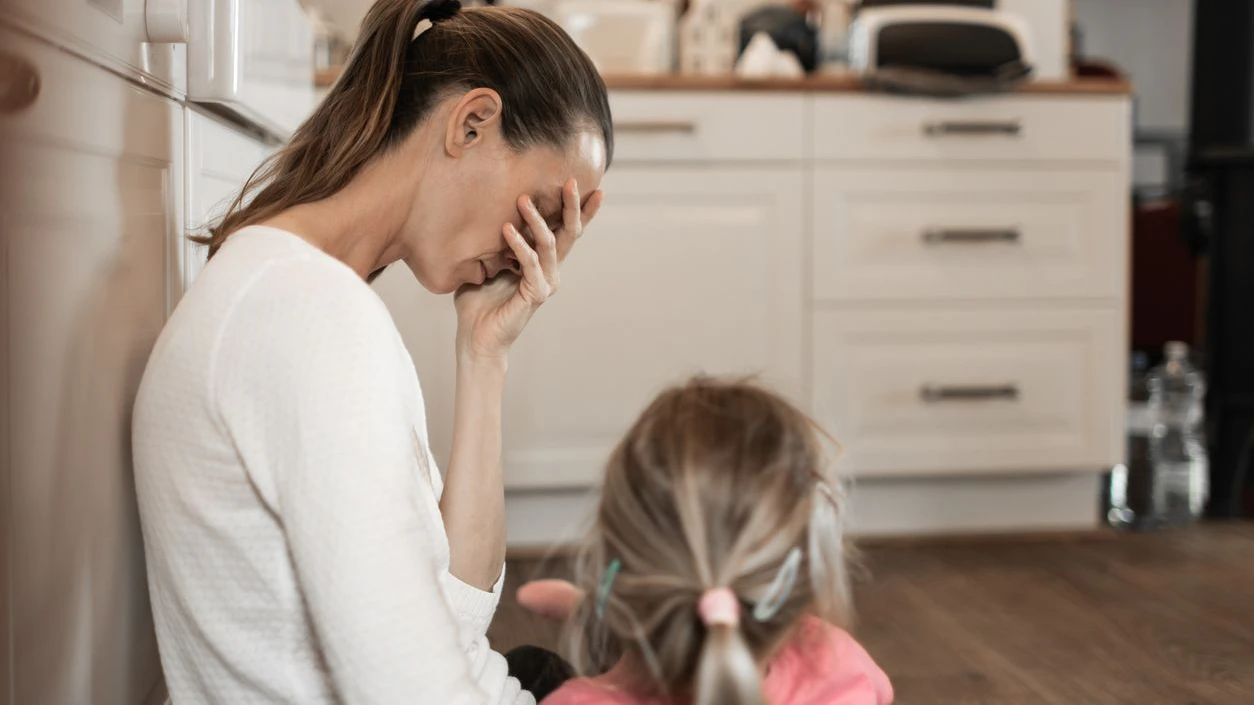 Tired stressed out mother with daughter.
